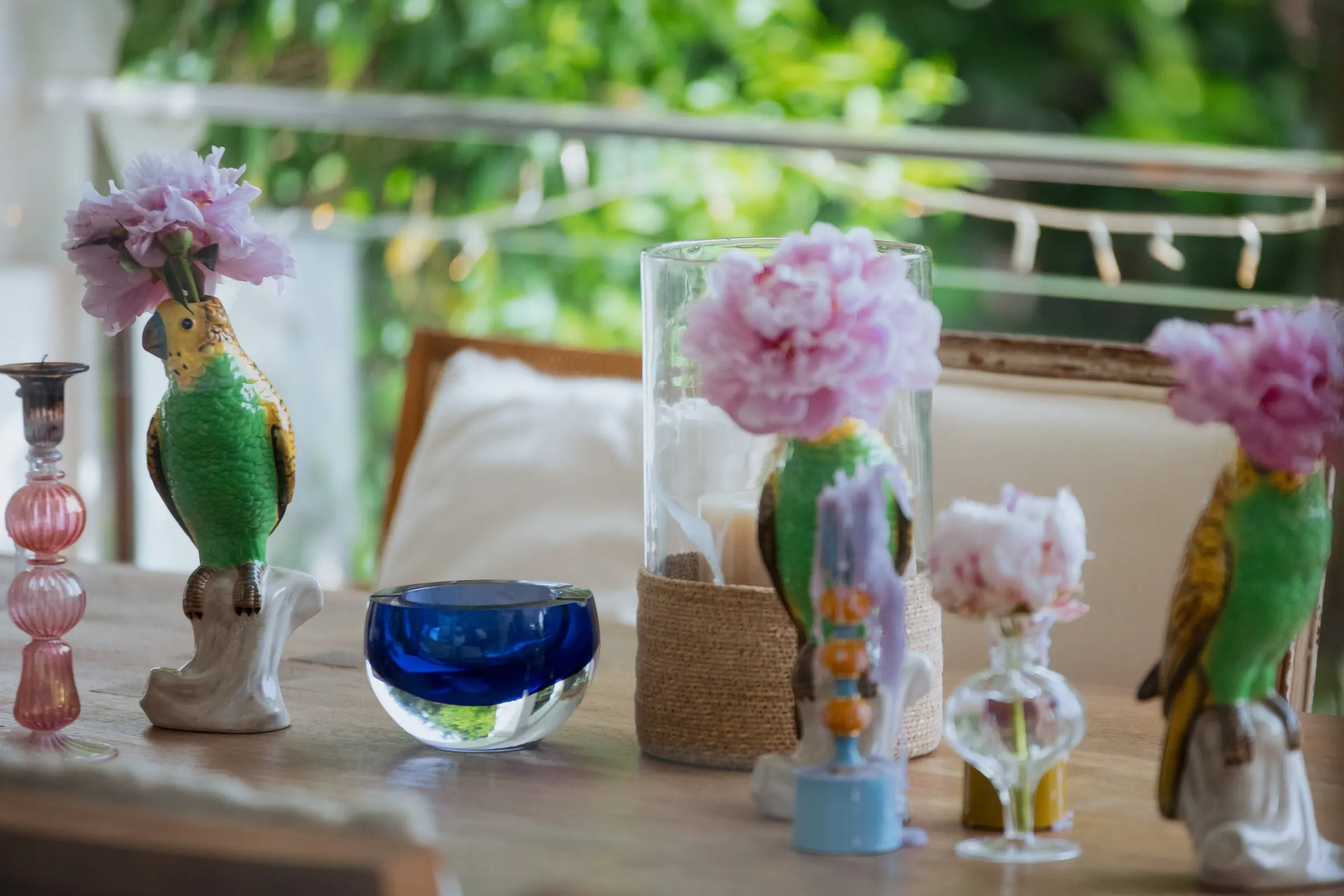 Green ceramic parrot vases with pink peonies on a table, Barbillón, Marbella