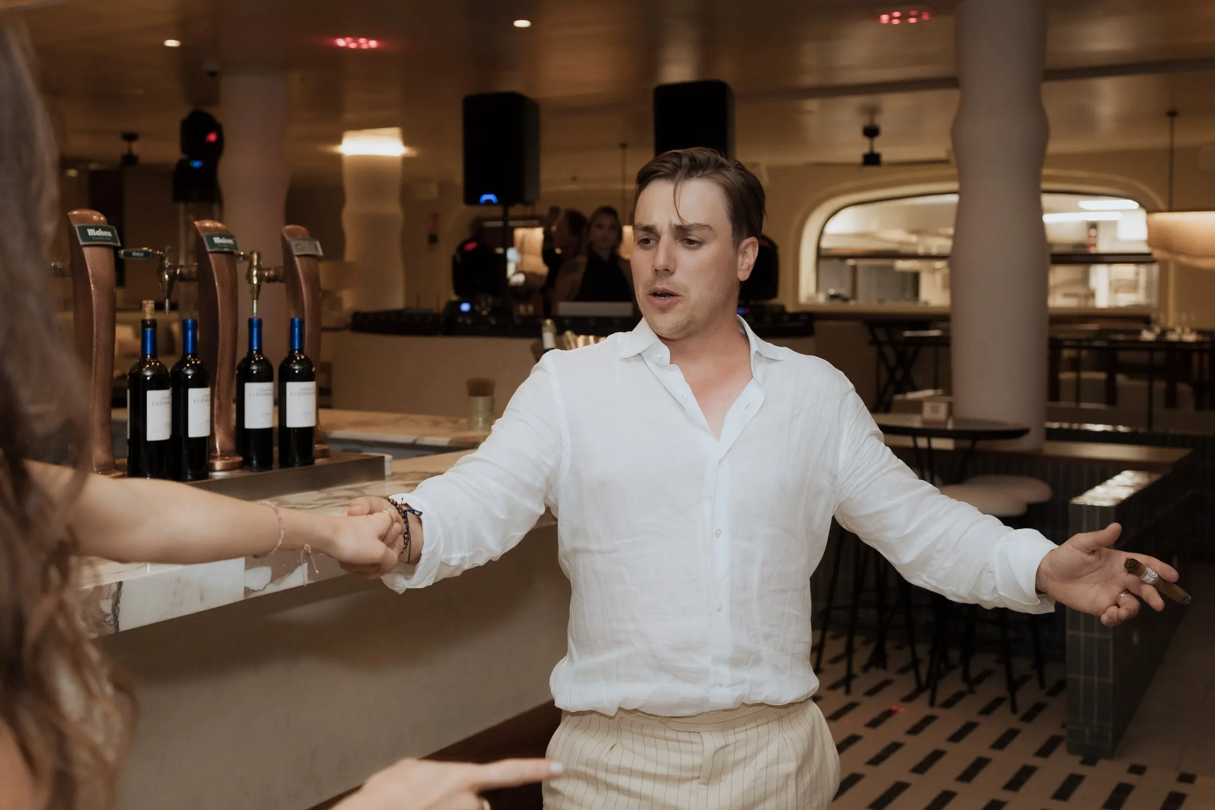 Groom in a white shirt dancing by the bar at the wedding party at Barbillón, Marbella