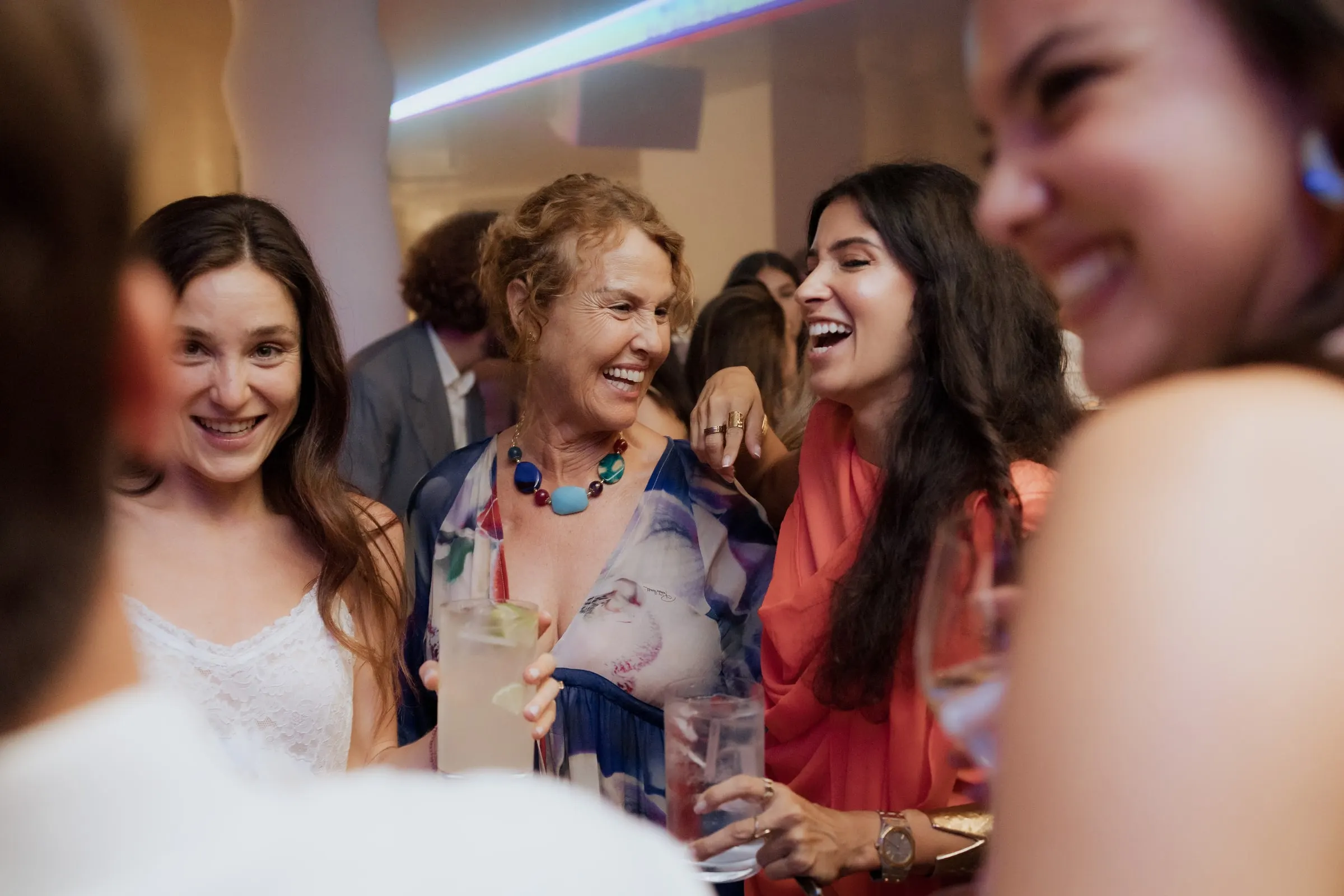 Bride laughing with women holding drinks at the wedding party at Barbillón, Marbella