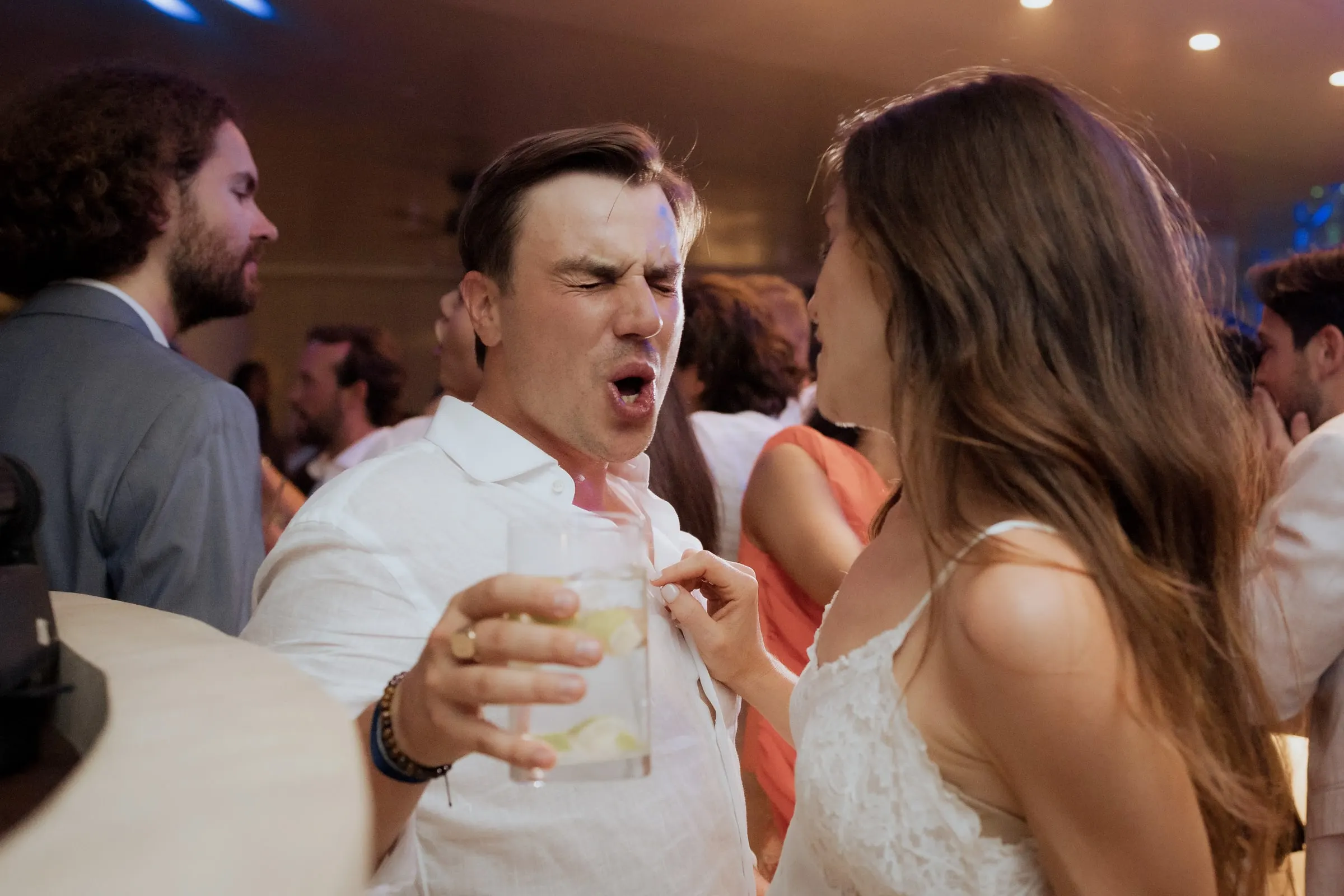 Groom singing with a drink in hand next to the bride on the dance floor at Barbillón, Marbella