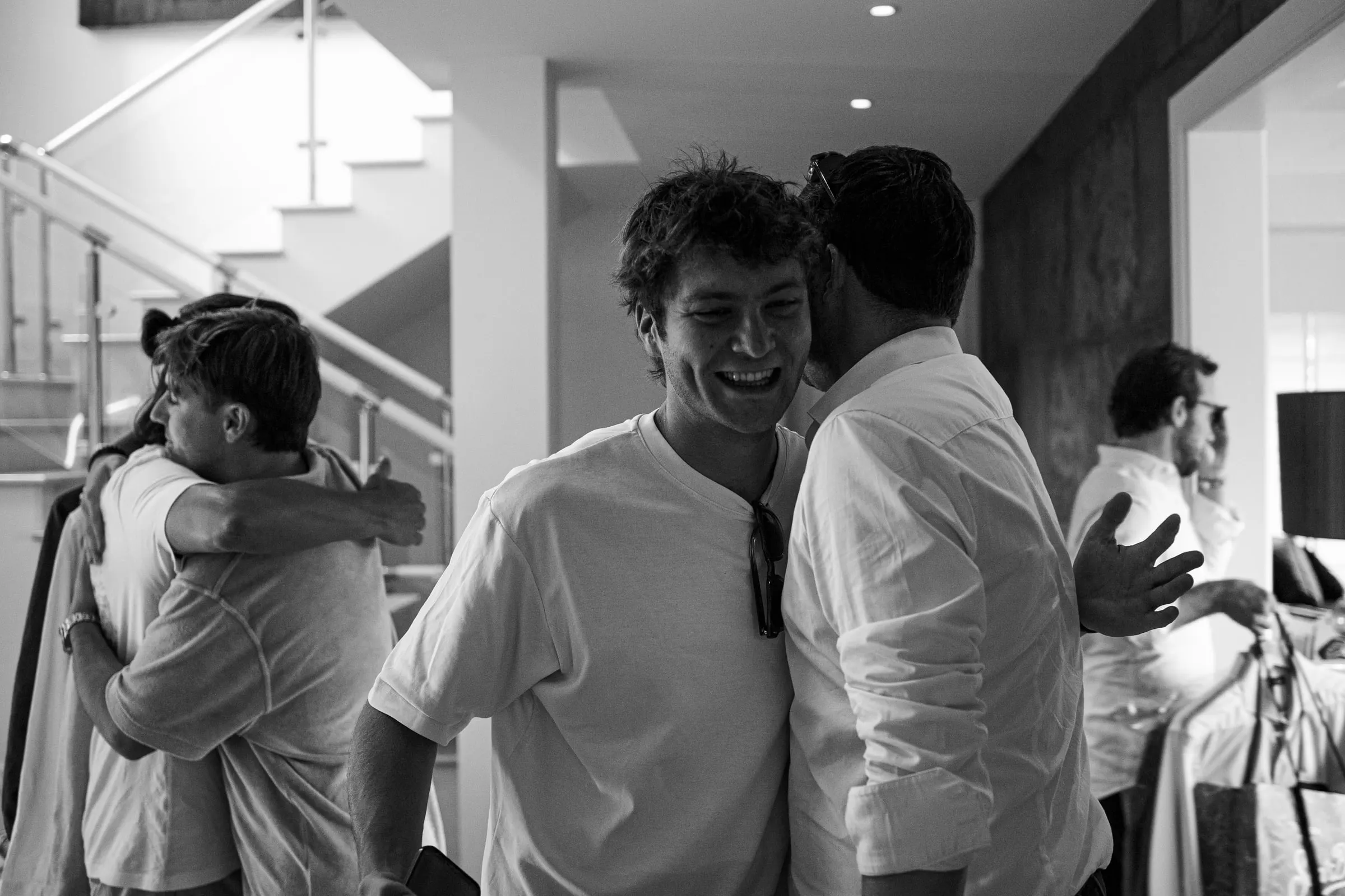 Black and white of the groom's friends hugging and laughing before the wedding, Barbillón, Marbella