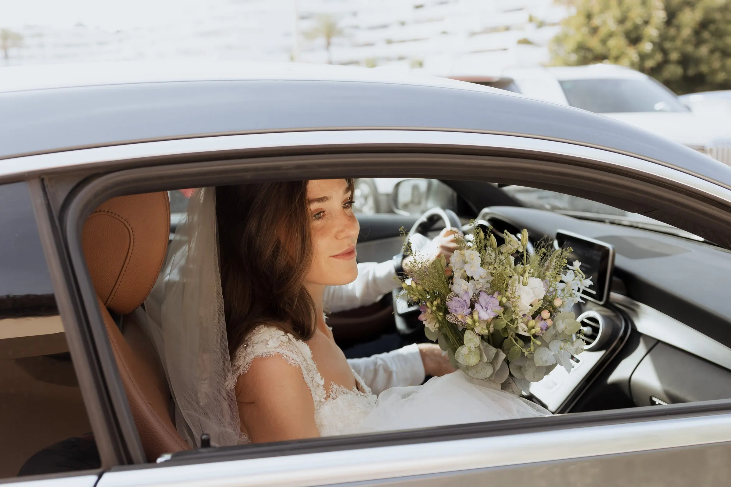 Bride sitting in the car with her bouquet of white and lilac flowers, Barbillón, Marbella