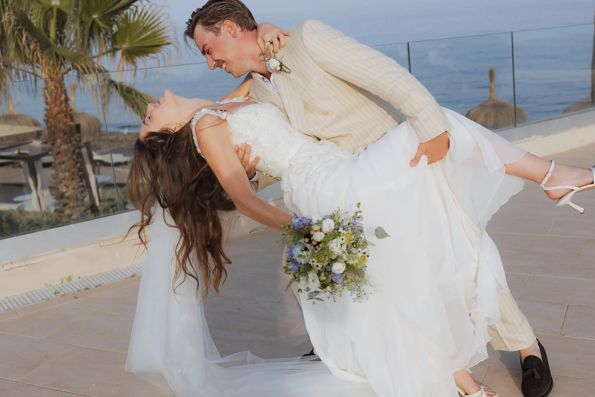 Groom dipping the bride in a dance move on the terrace above the sea, Barbillón, Marbella
