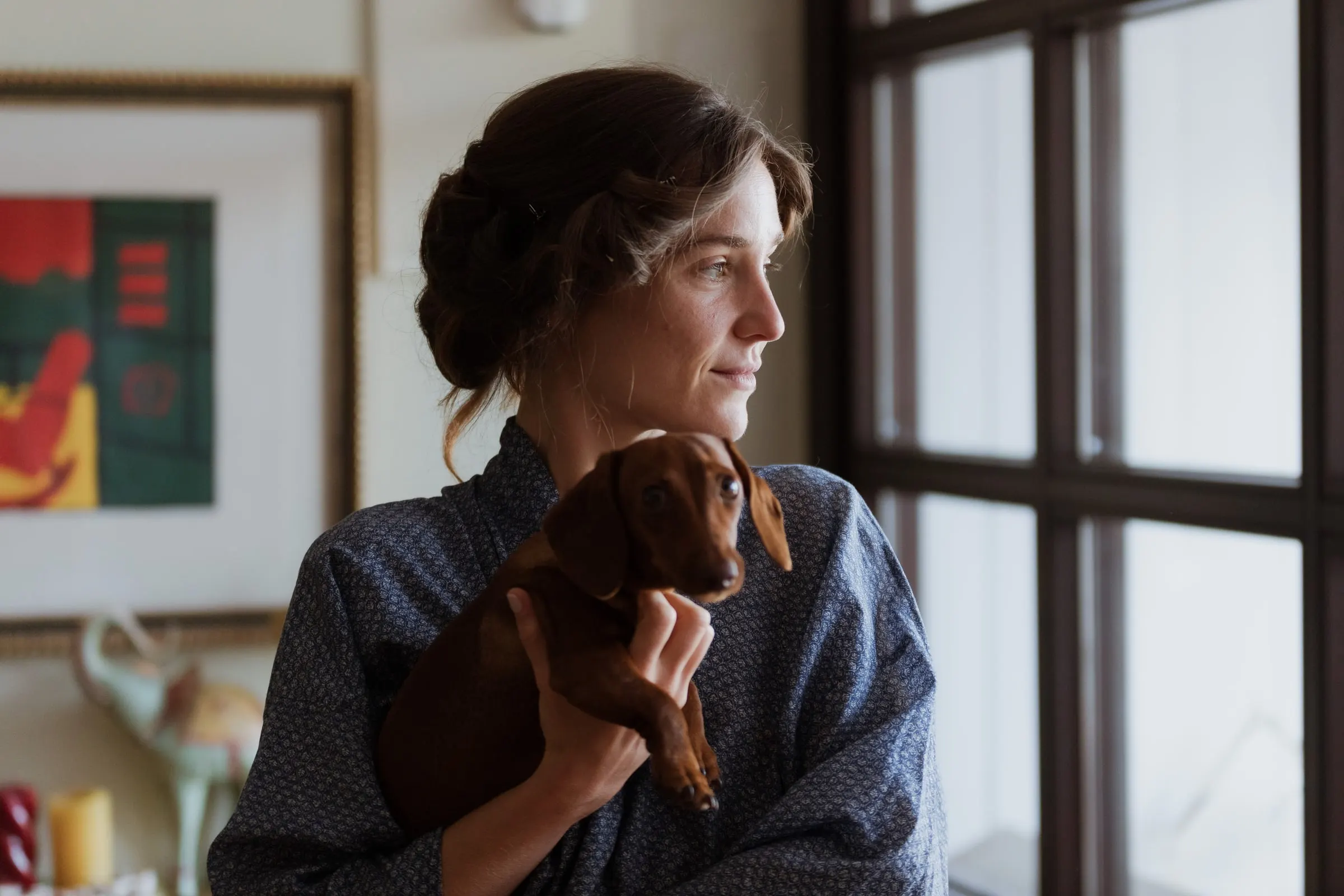 Bride in a blue robe holding her dachshund by the window, Barbillón, Marbella
