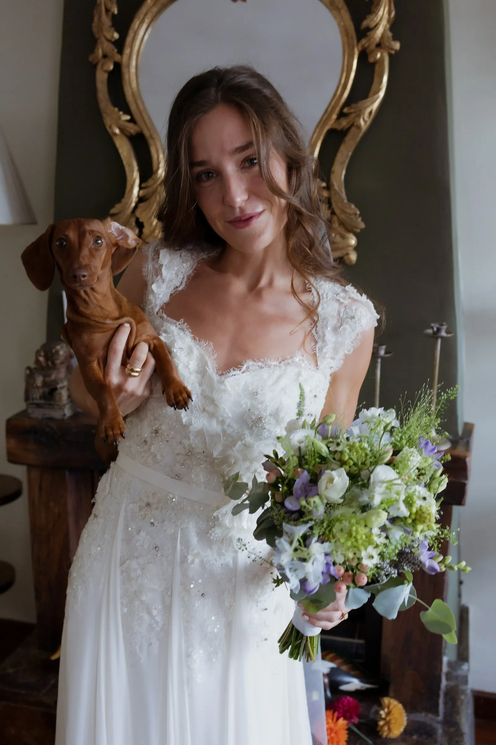 Bride holding her bouquet and her dachshund in front of a gilded mirror, Barbillón, Marbella