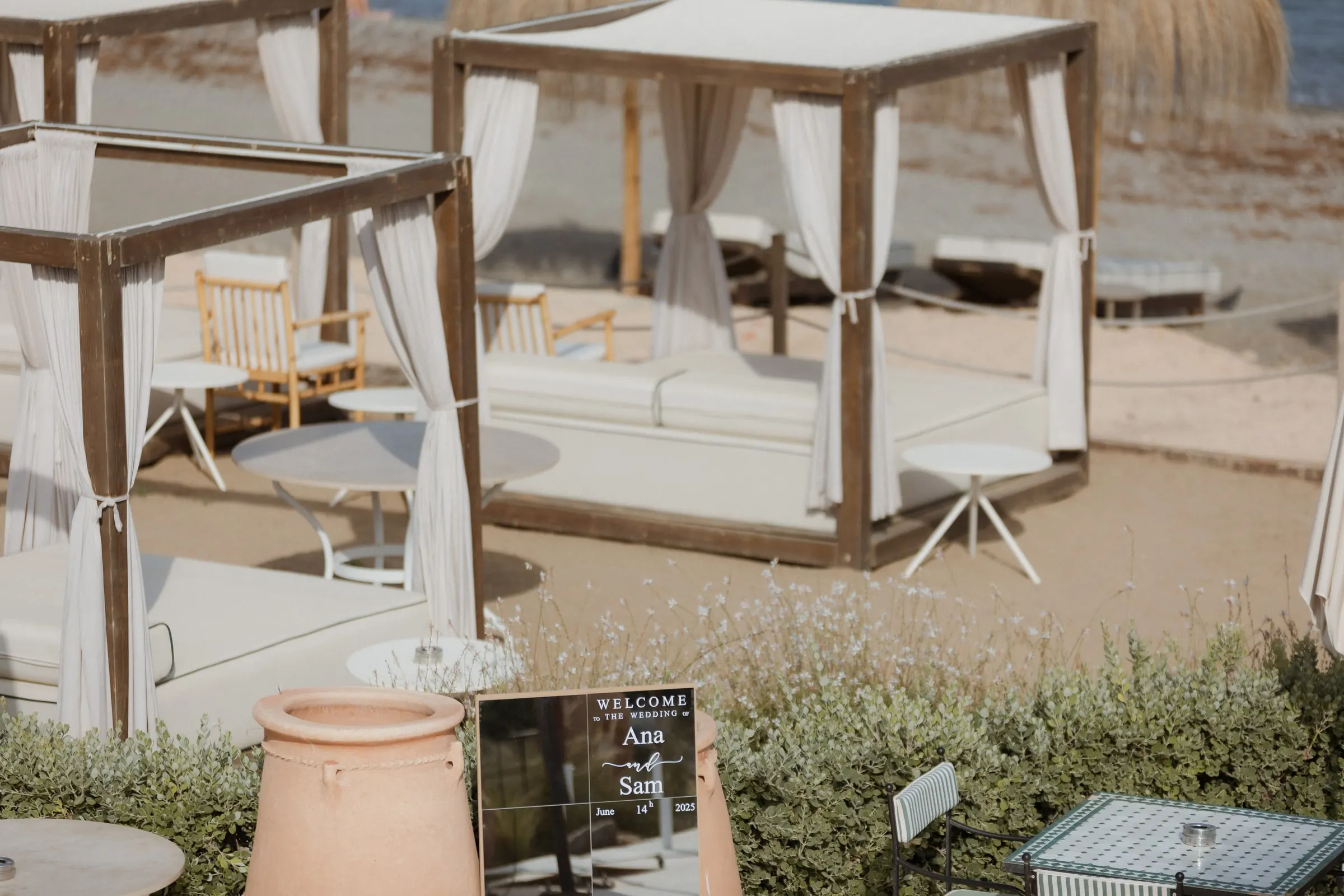 Welcome sign on a terracotta pot beside white daybeds by the beach, Barbillón, Marbella