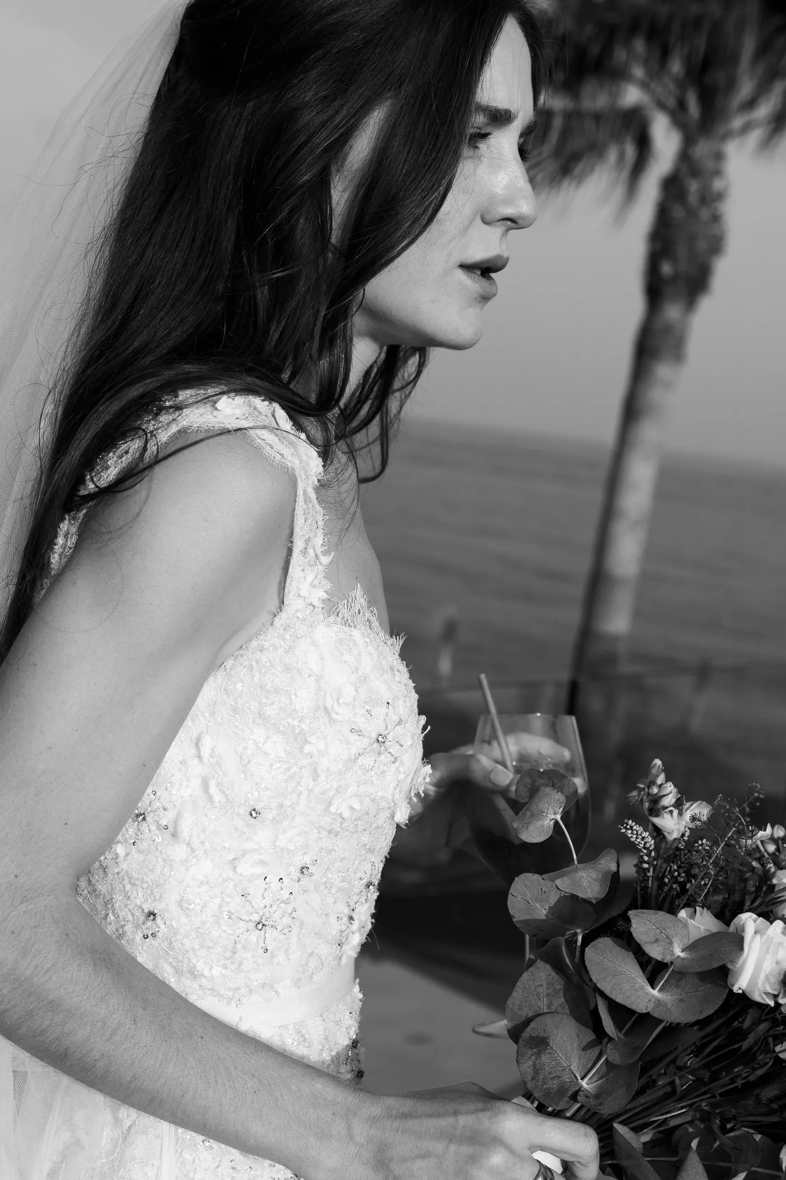 Black and white close-up of the bride in profile with a palm tree behind, Barbillón, Marbella