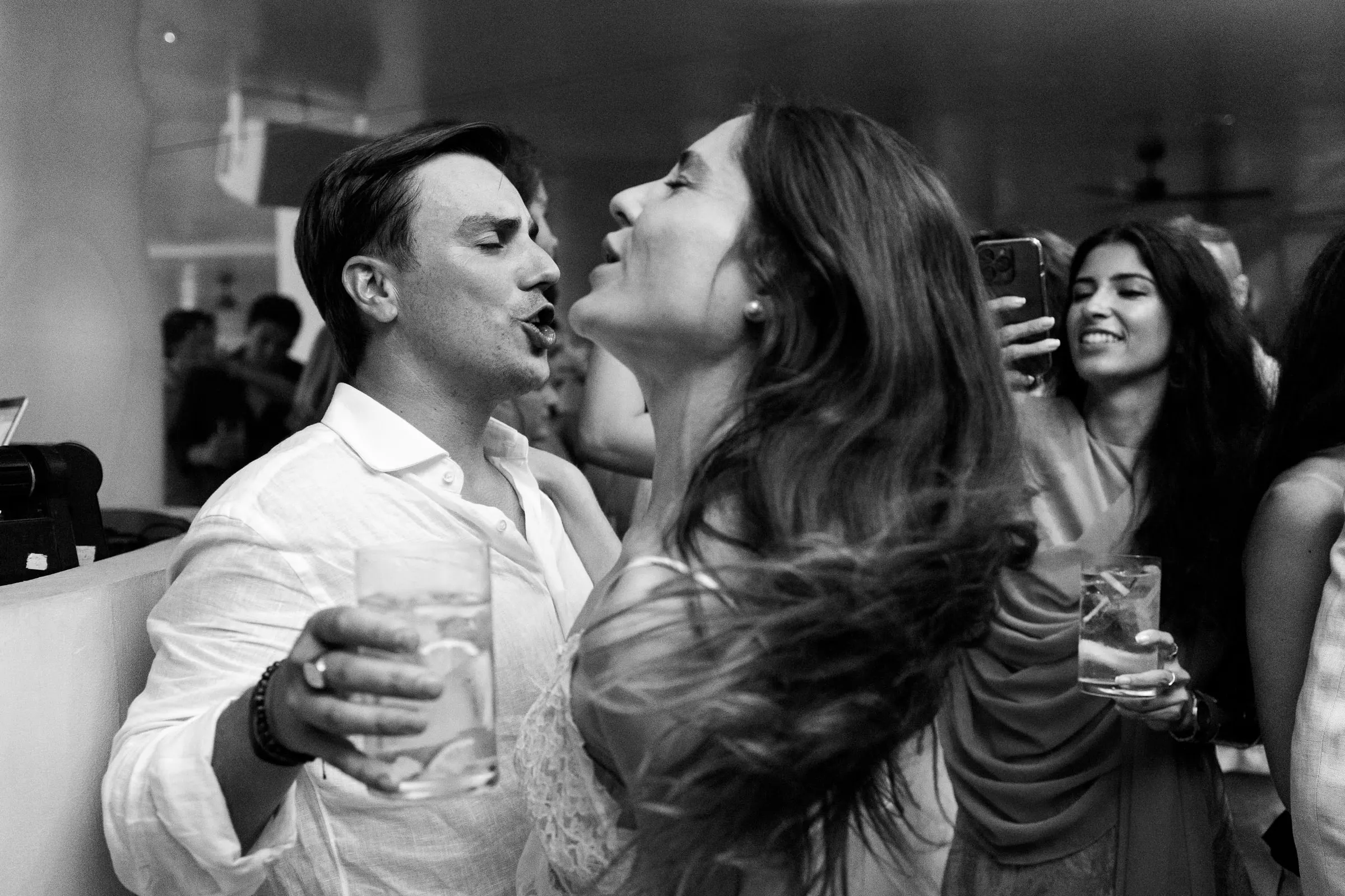 Black and white of the couple singing with drinks in hand at the party, Barbillón, Marbella