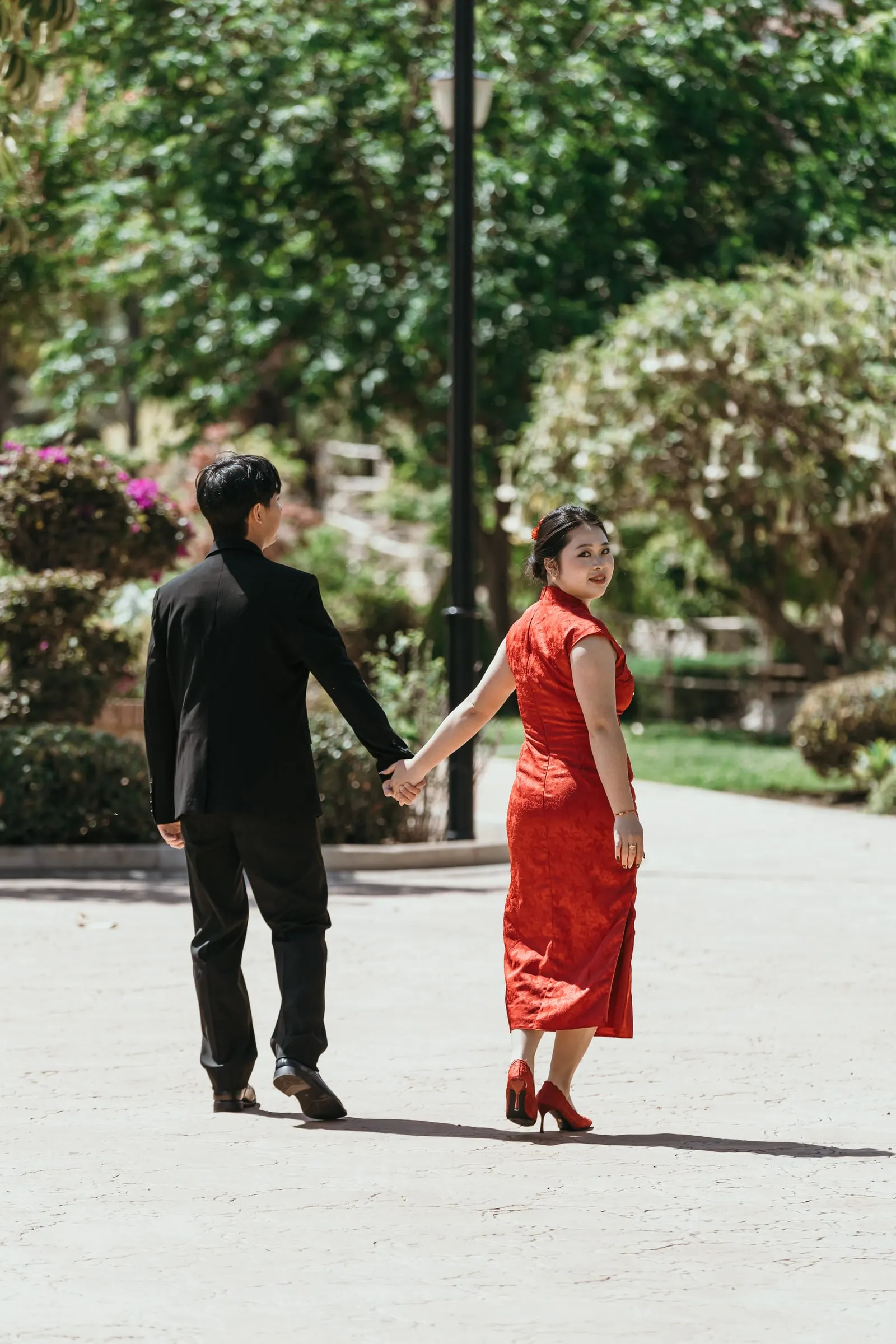 Couple walking hand in hand along a sunny path in the Jardín Oriental Bienquerido