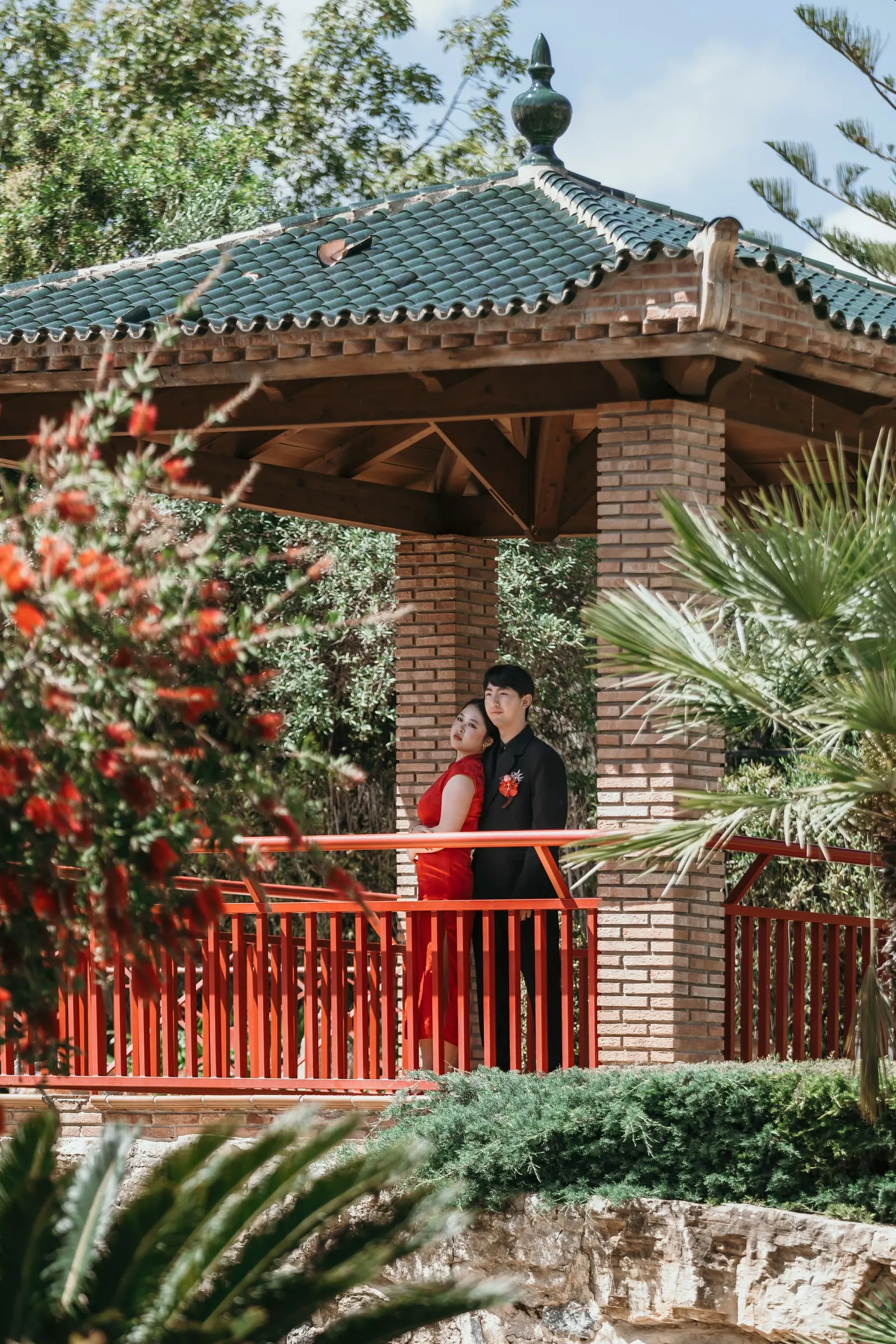 Couple beneath the green-tiled roof of a pagoda in the Jardín Oriental Bienquerido