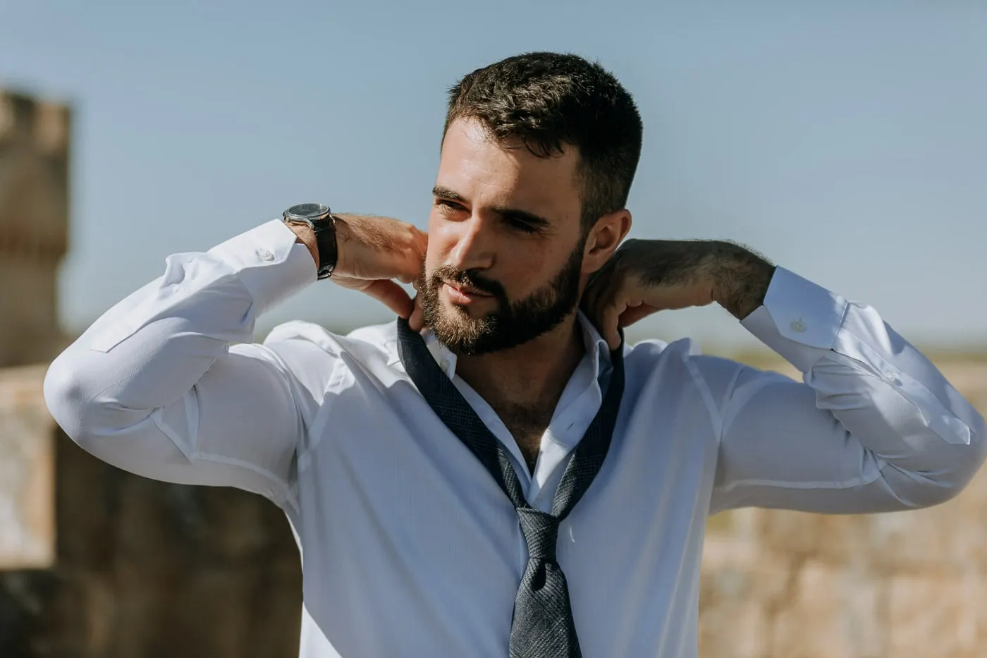 Groom adjusting his collar with his tie loose around his neck, Salamanca