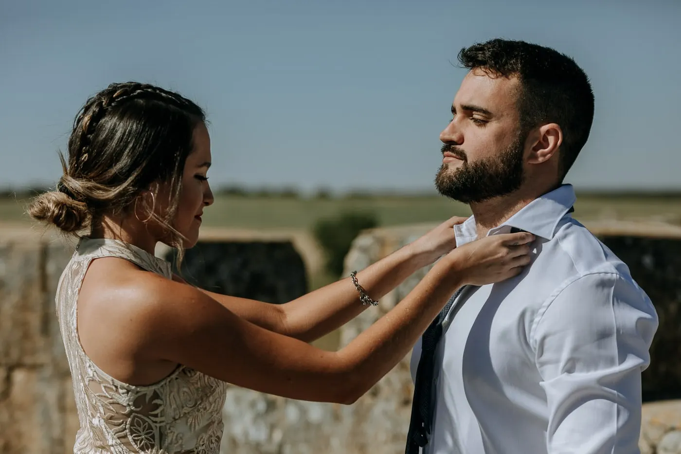 Friend in a lace dress straightening the groom's collar on the castle roof, Castillo del Buen Amor