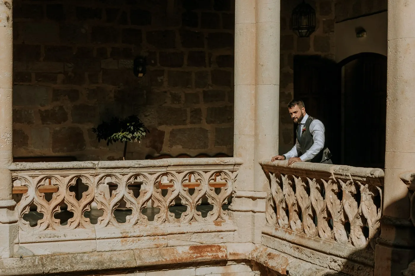 Groom waiting on the carved stone balcony of the castle courtyard, Castillo del Buen Amor