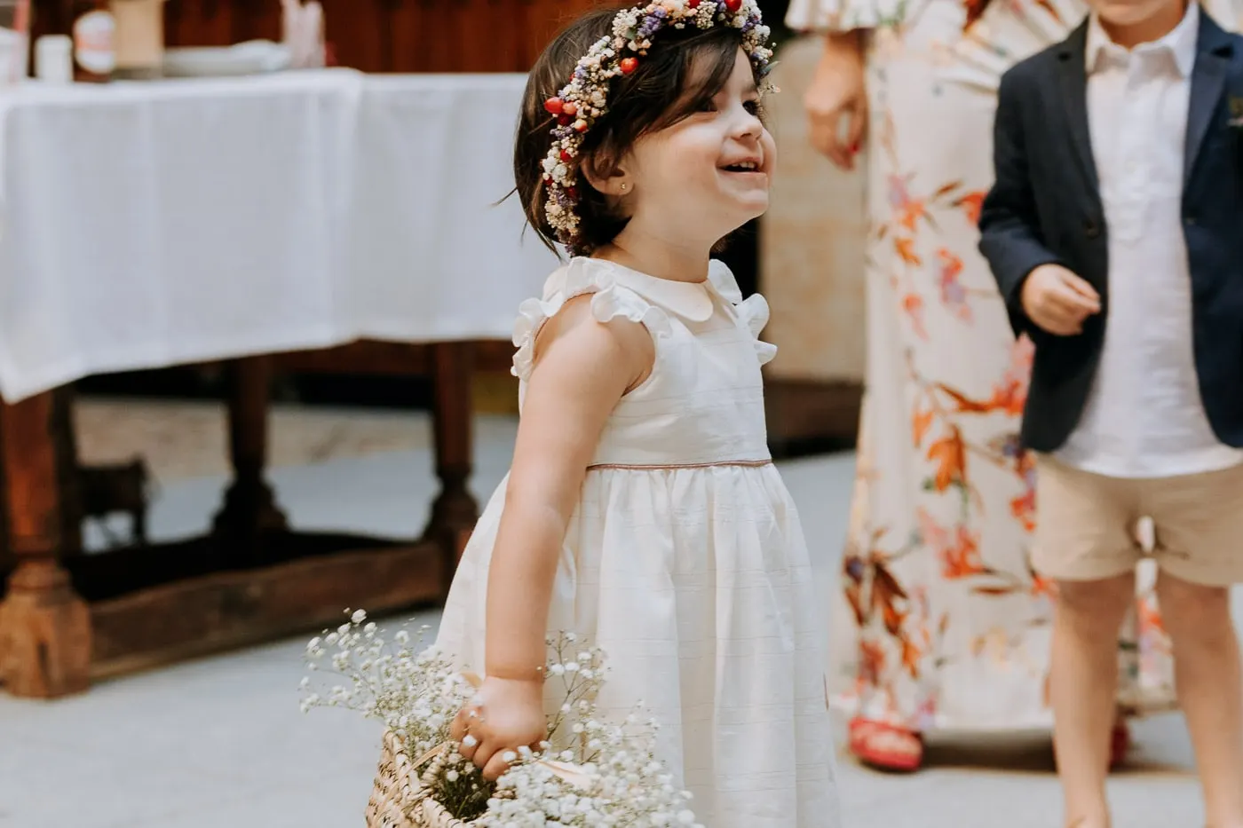 Little girl with a flower crown laughing among the guests, Castillo del Buen Amor