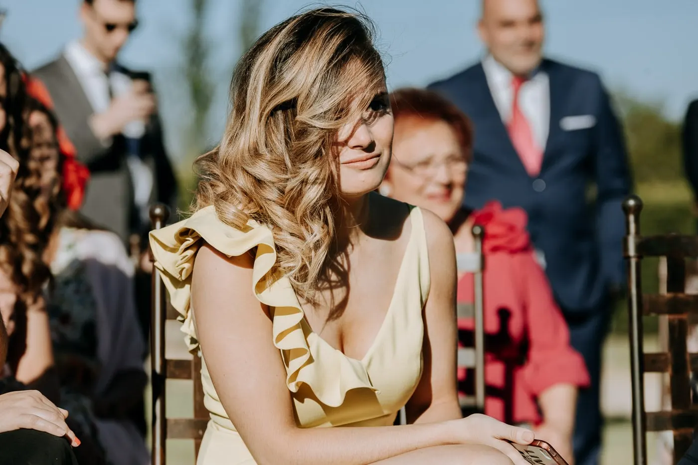Guest in a yellow ruffled dress watching the ceremony, Castillo del Buen Amor