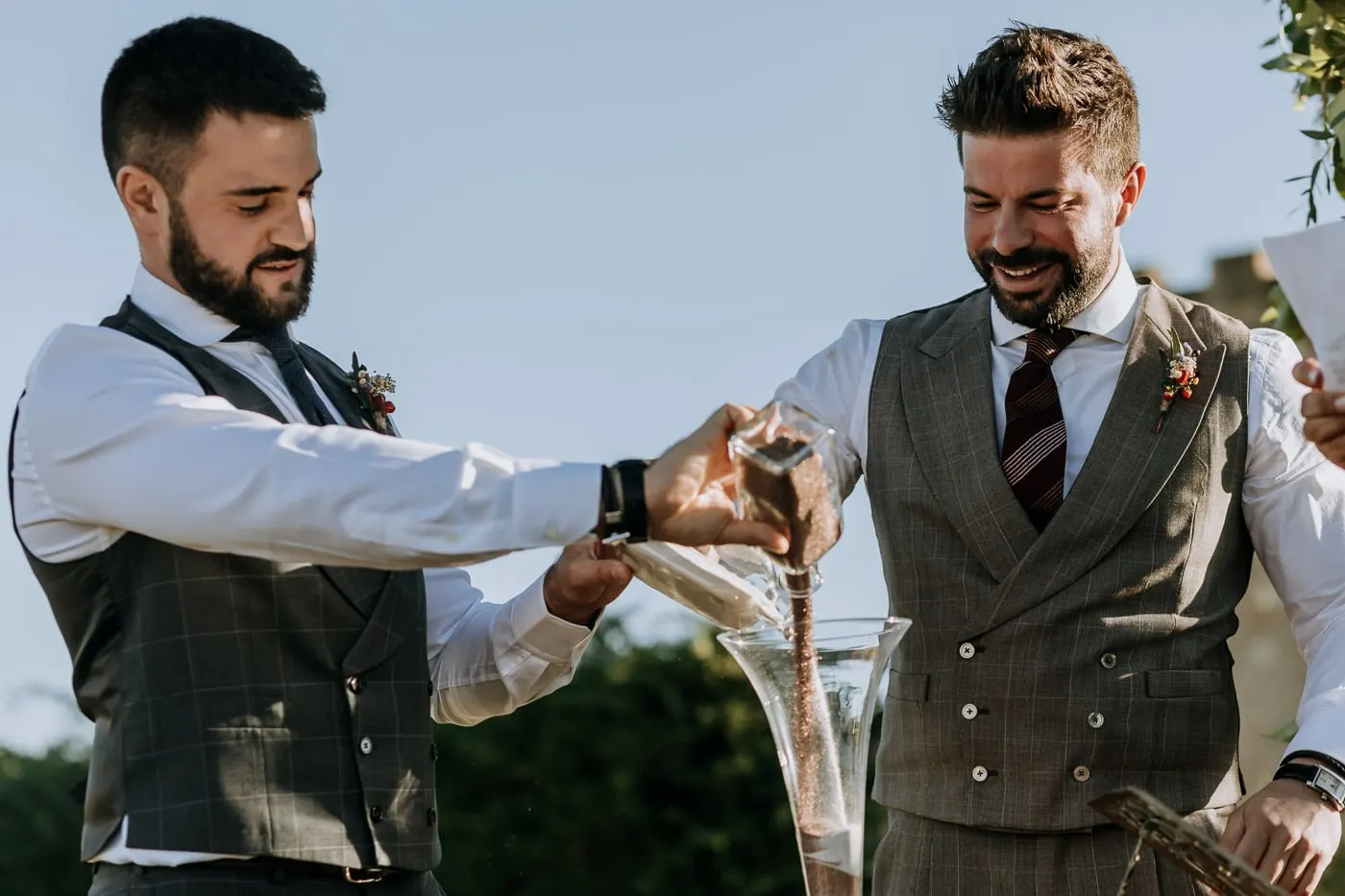 The grooms pouring sand together in a sand ceremony, Castillo del Buen Amor