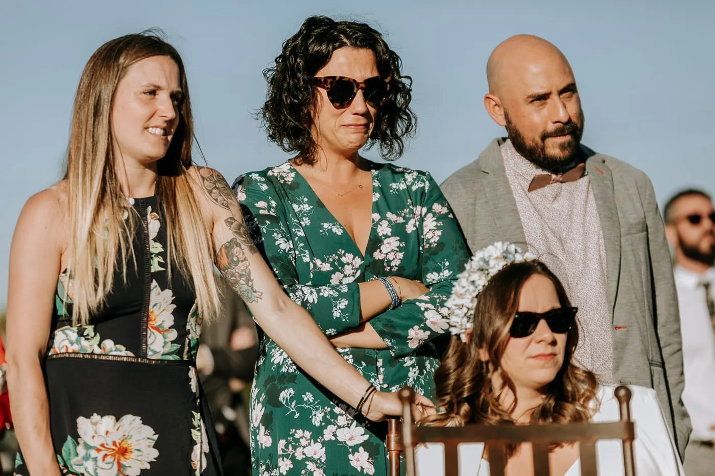 Friends watching the ceremony, one with a flower crown, Castillo del Buen Amor