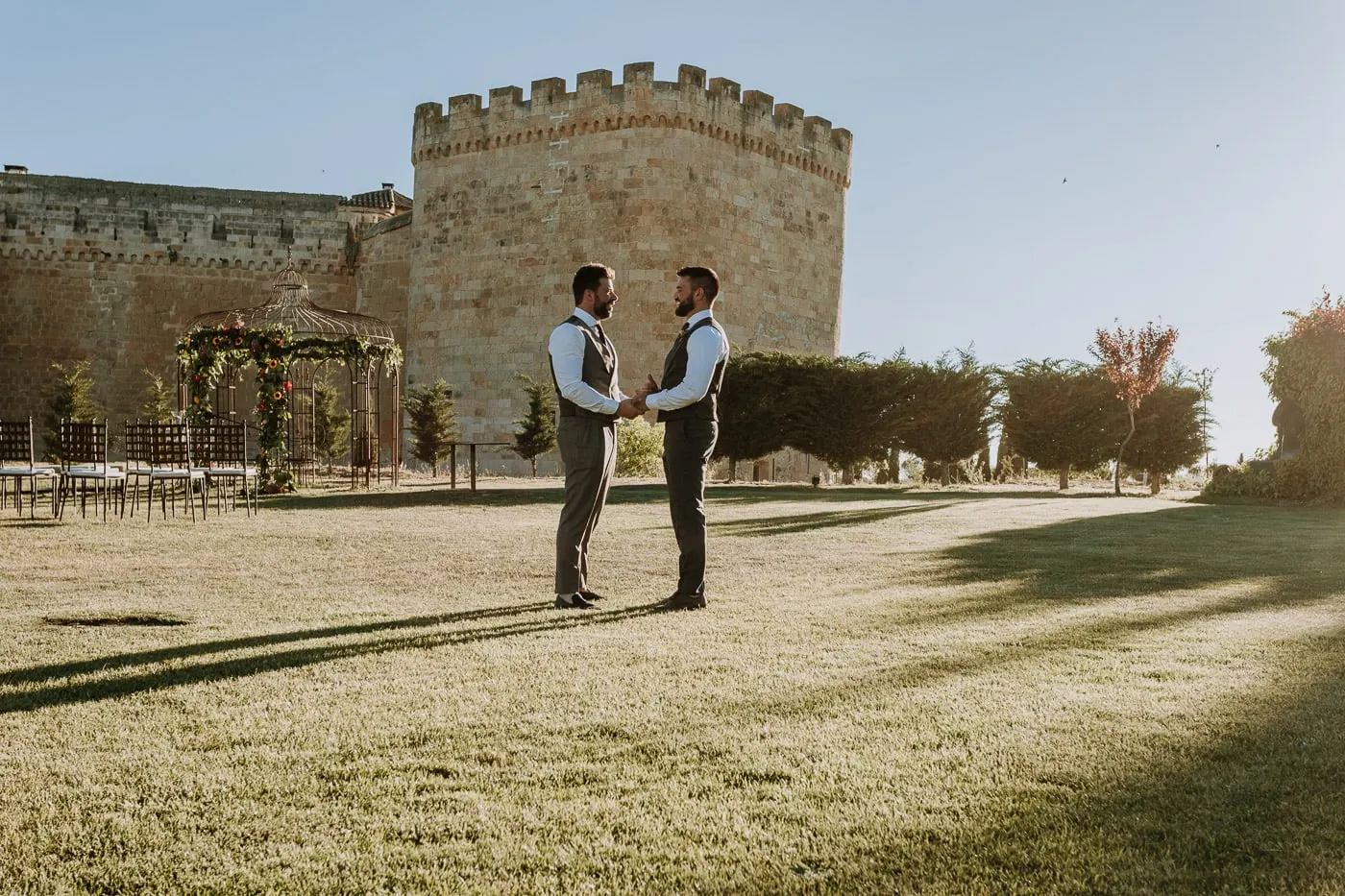 The grooms alone on the lawn before the keep of Castillo del Buen Amor at sunset, Salamanca