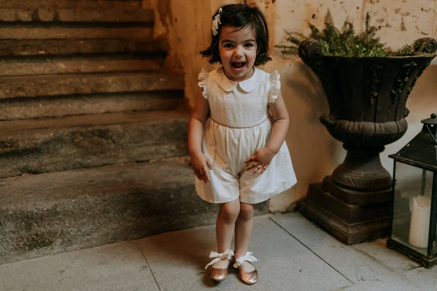 Little girl laughing at the foot of the castle stone stairs, Castillo del Buen Amor