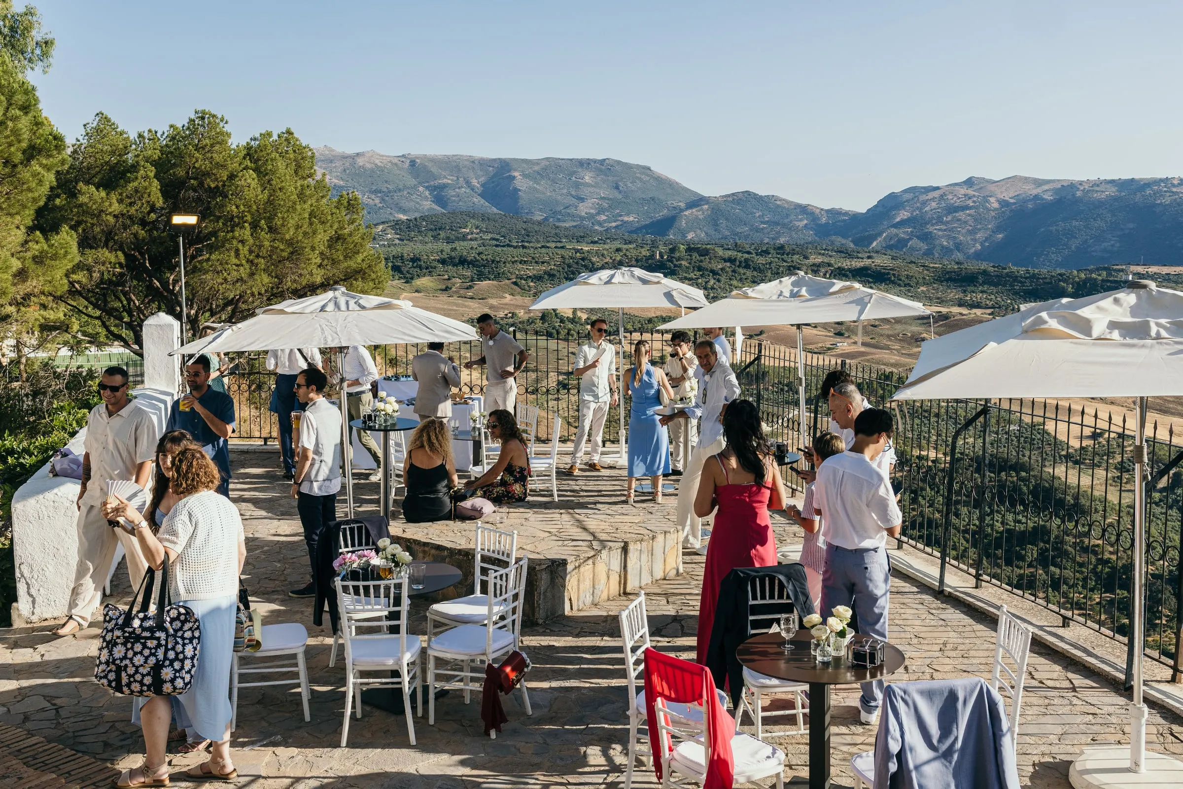 Cocktail on the terrace under white parasols, with the mountains of Ronda in view