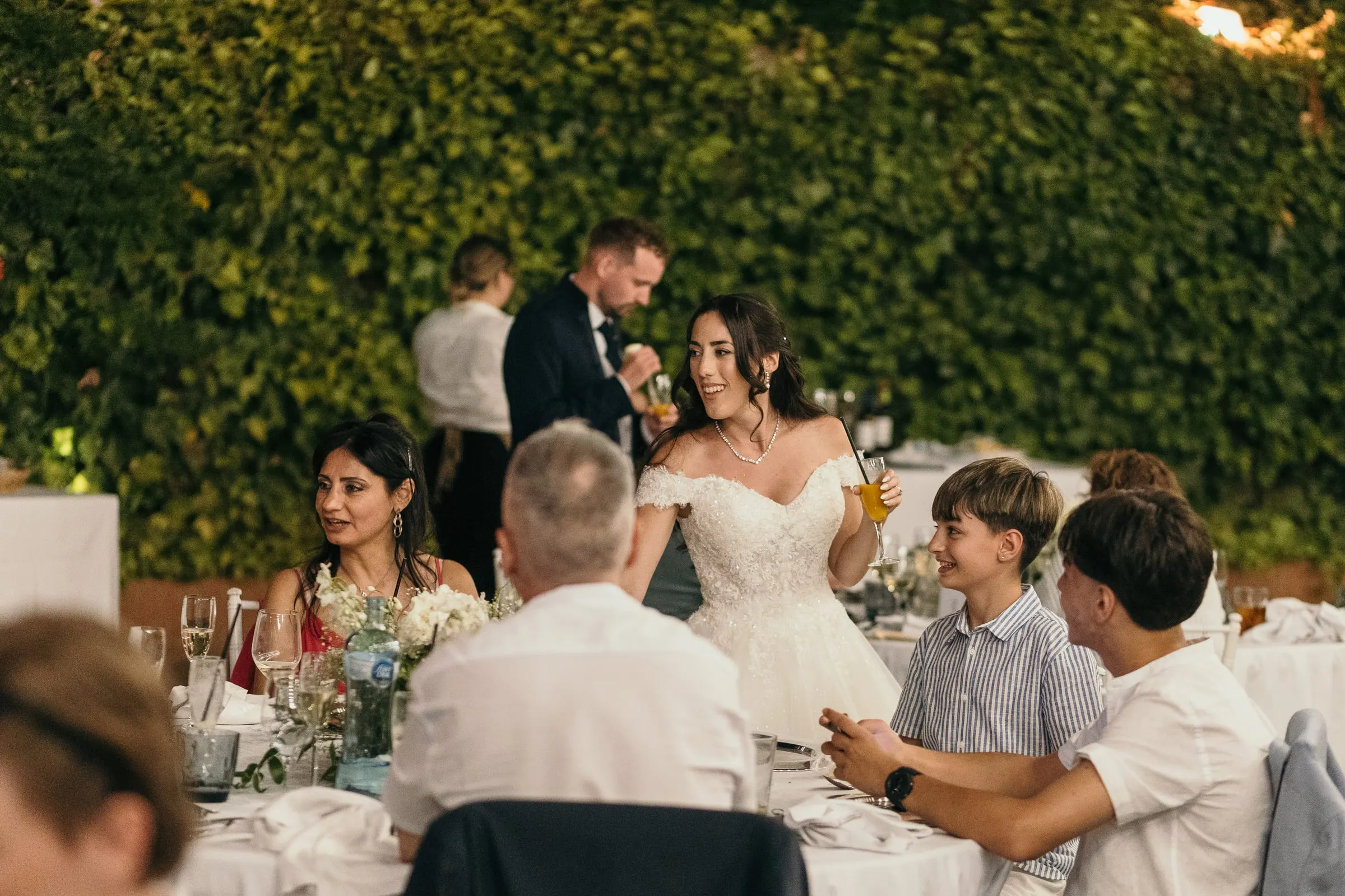 The couple stop to talk with guests at their table during dinner