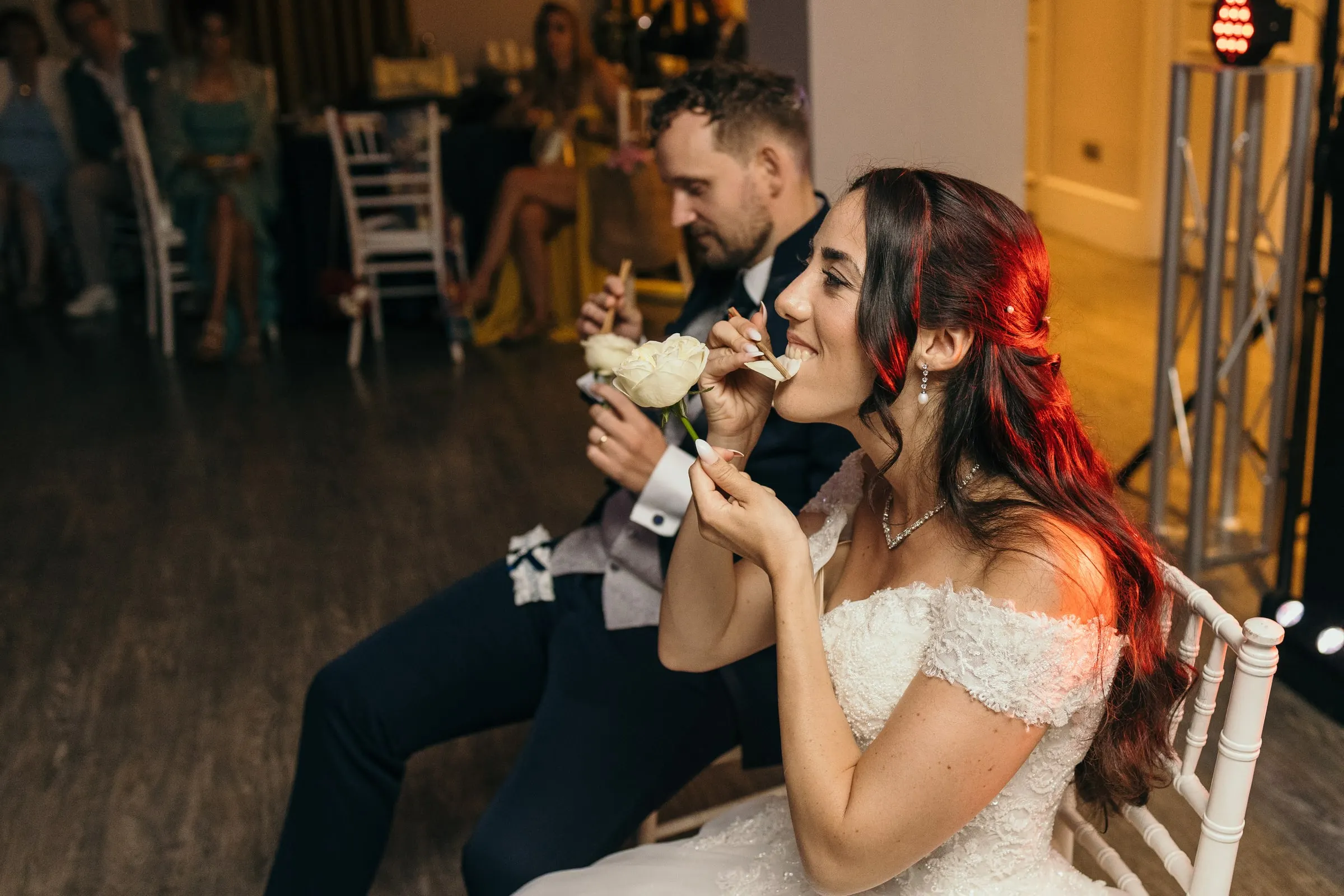 Sara laughs on a chair as Vincent sits beside her in the party room