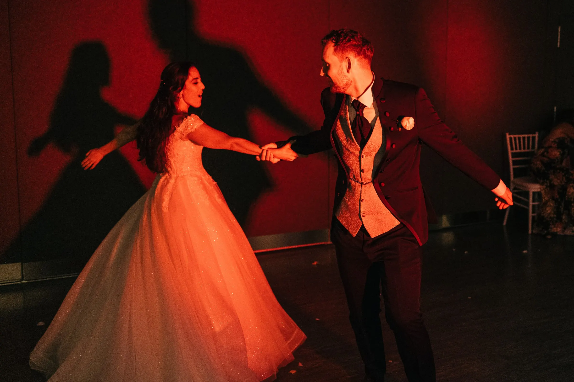 Vincent twirls Sara across the dance floor in red light