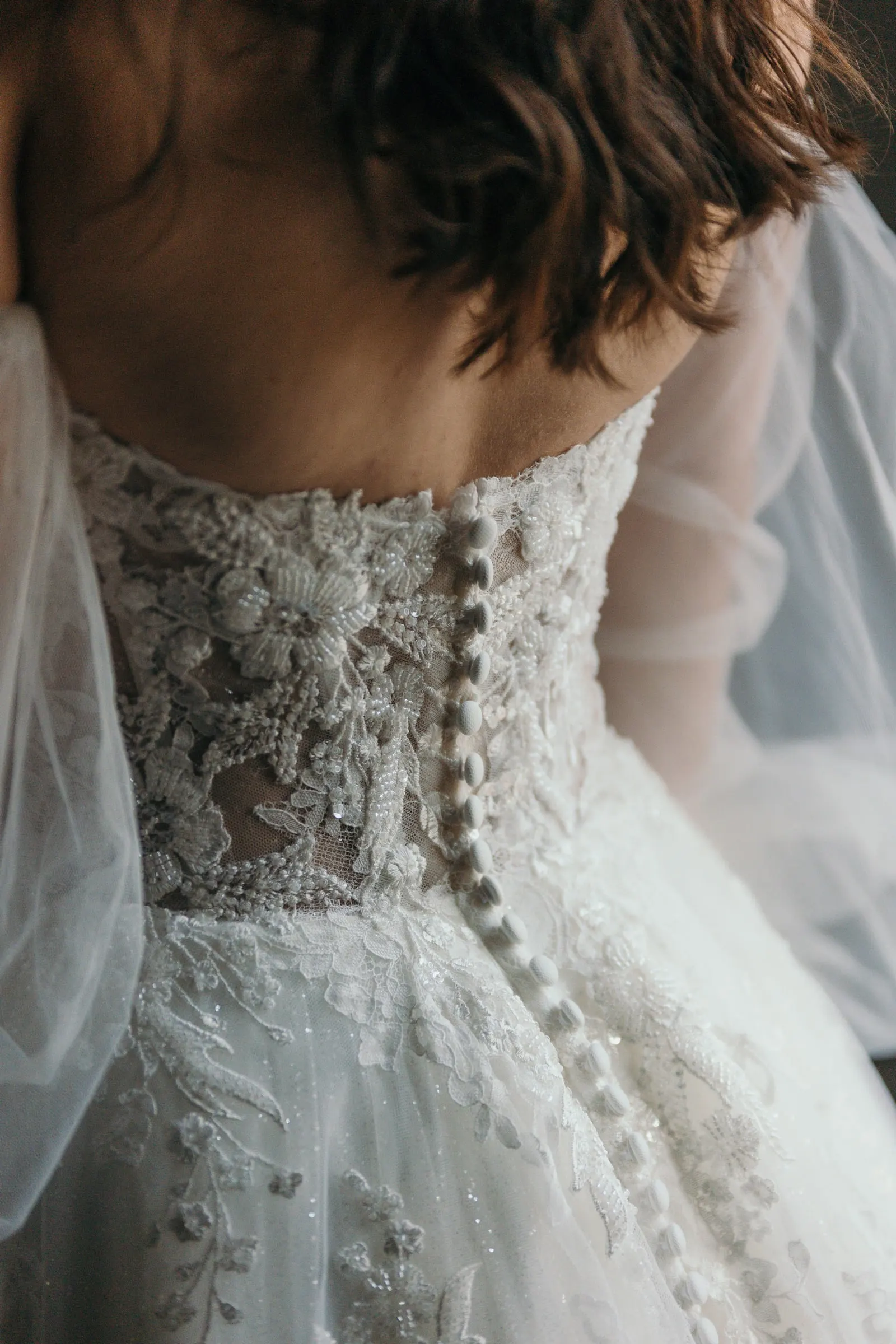 Close-up of the lace bodice and covered buttons on the back of the bridal gown, Cortijo San Francisco, Estepona