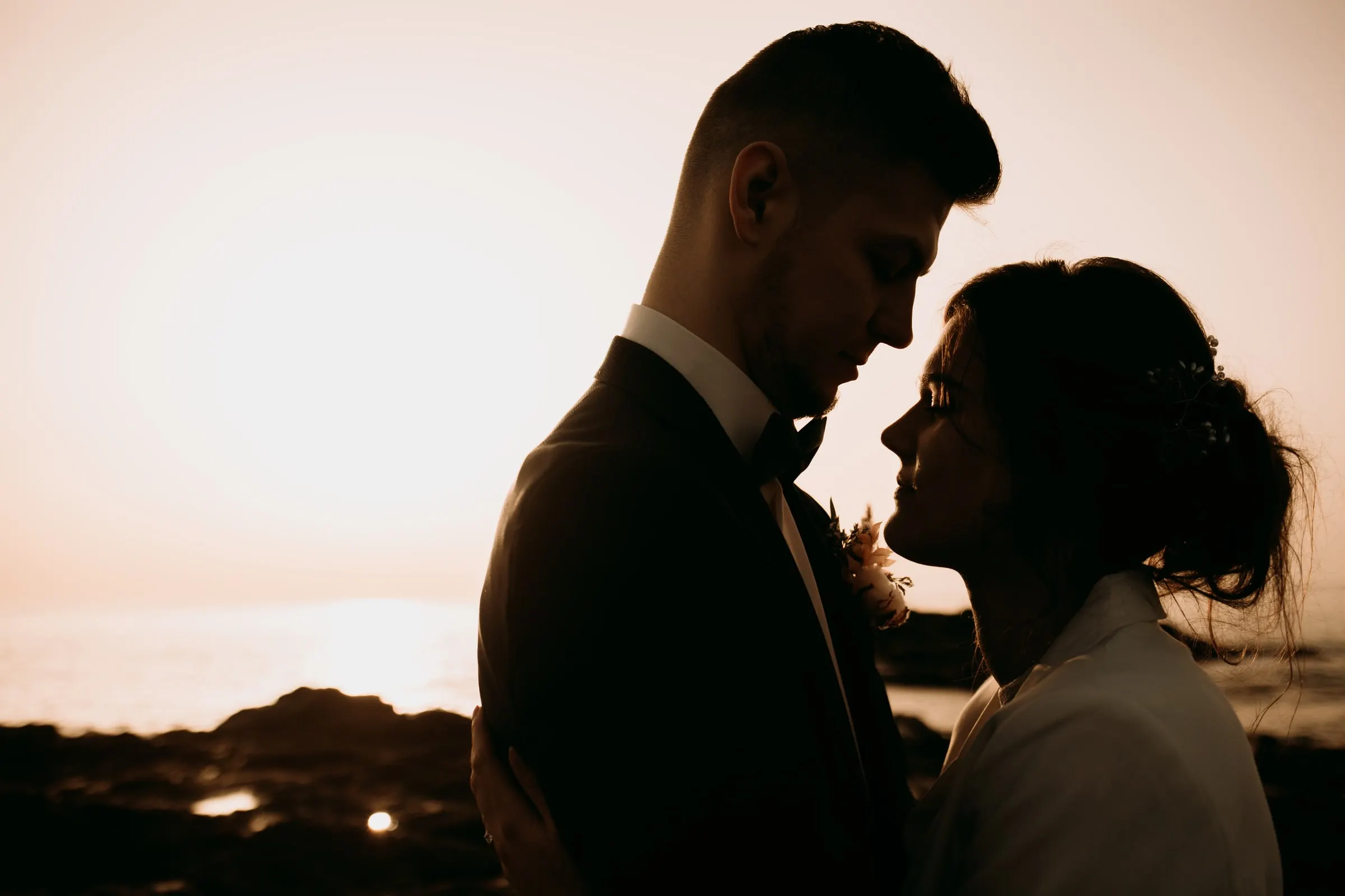 Los novios a contraluz a punto de besarse con la luz de la tarde