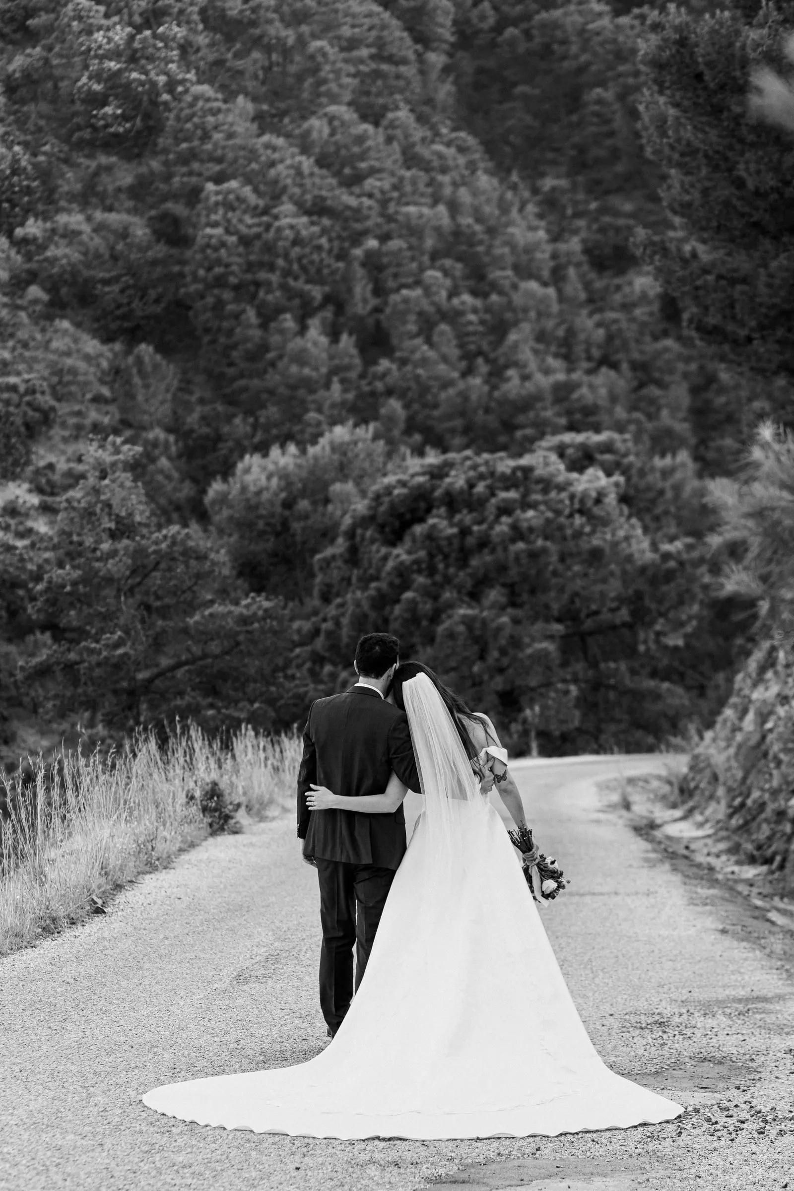 Black and white of the couple walking away down the mountain road