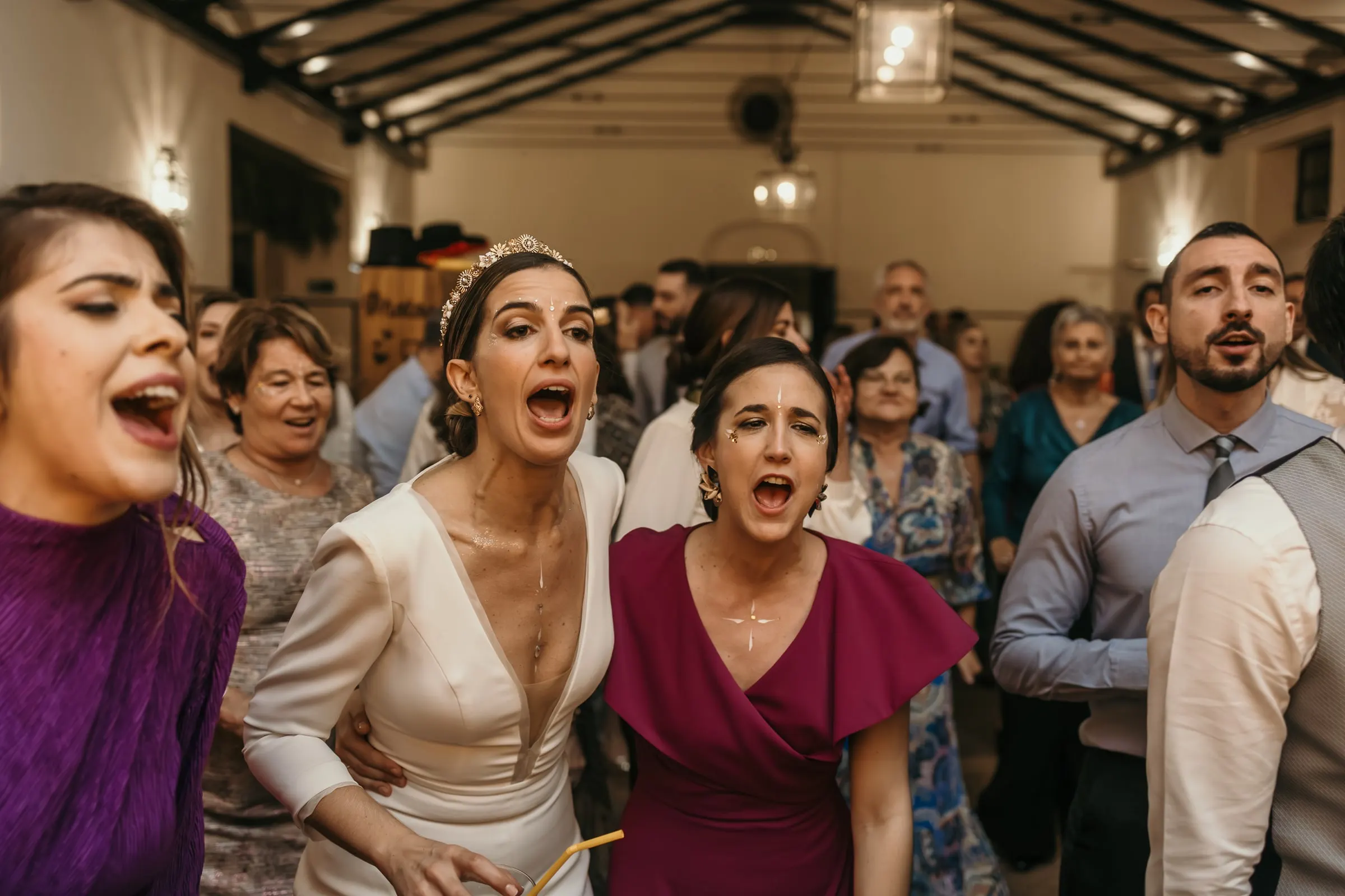 Bride singing at the top of her voice with friends on the dance floor