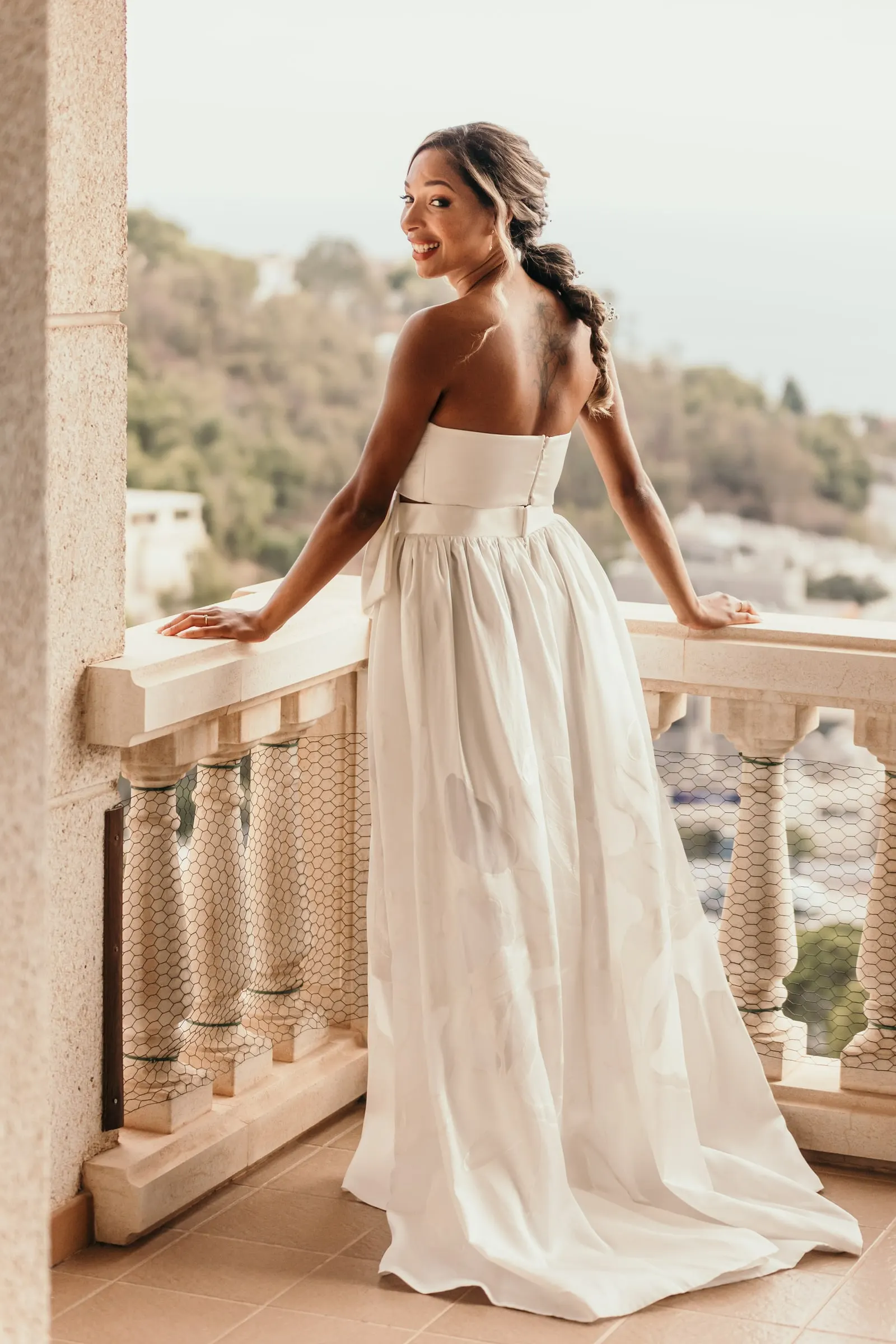 Bride glancing over her shoulder at the balustrade with the hills of the Costa del Sol behind
