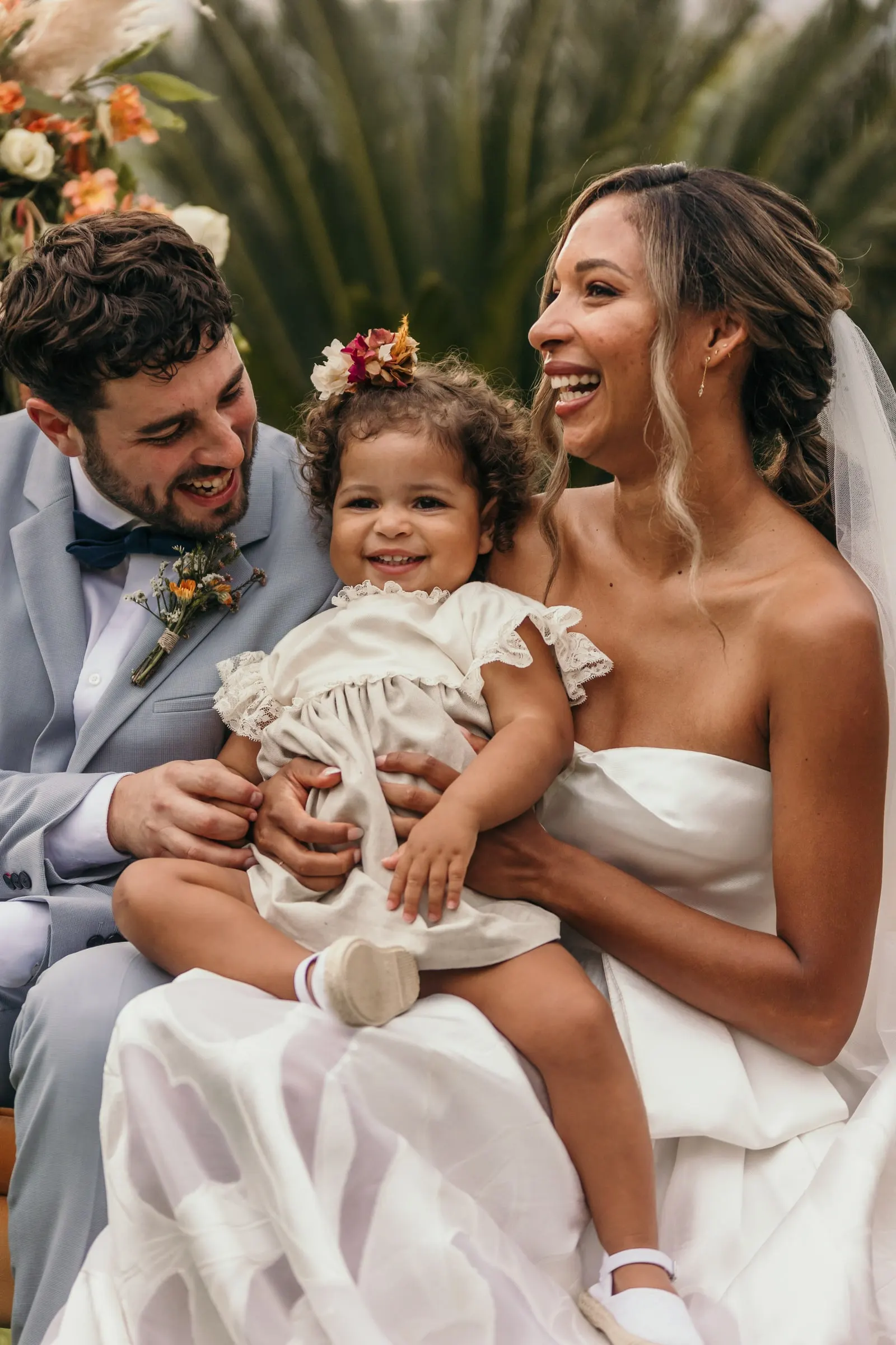 Little girl beaming on the couple's laps during the ceremony