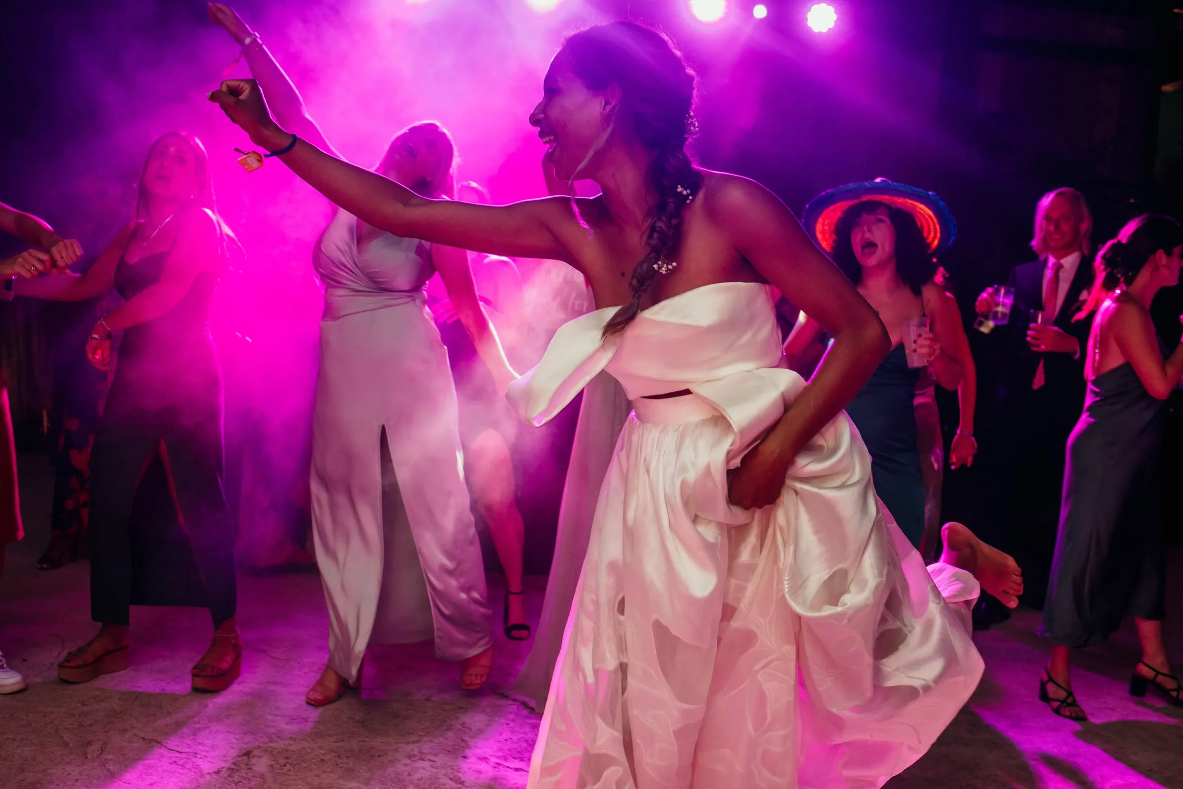 Bride dancing with friends under pink lights at the party on the Costa del Sol