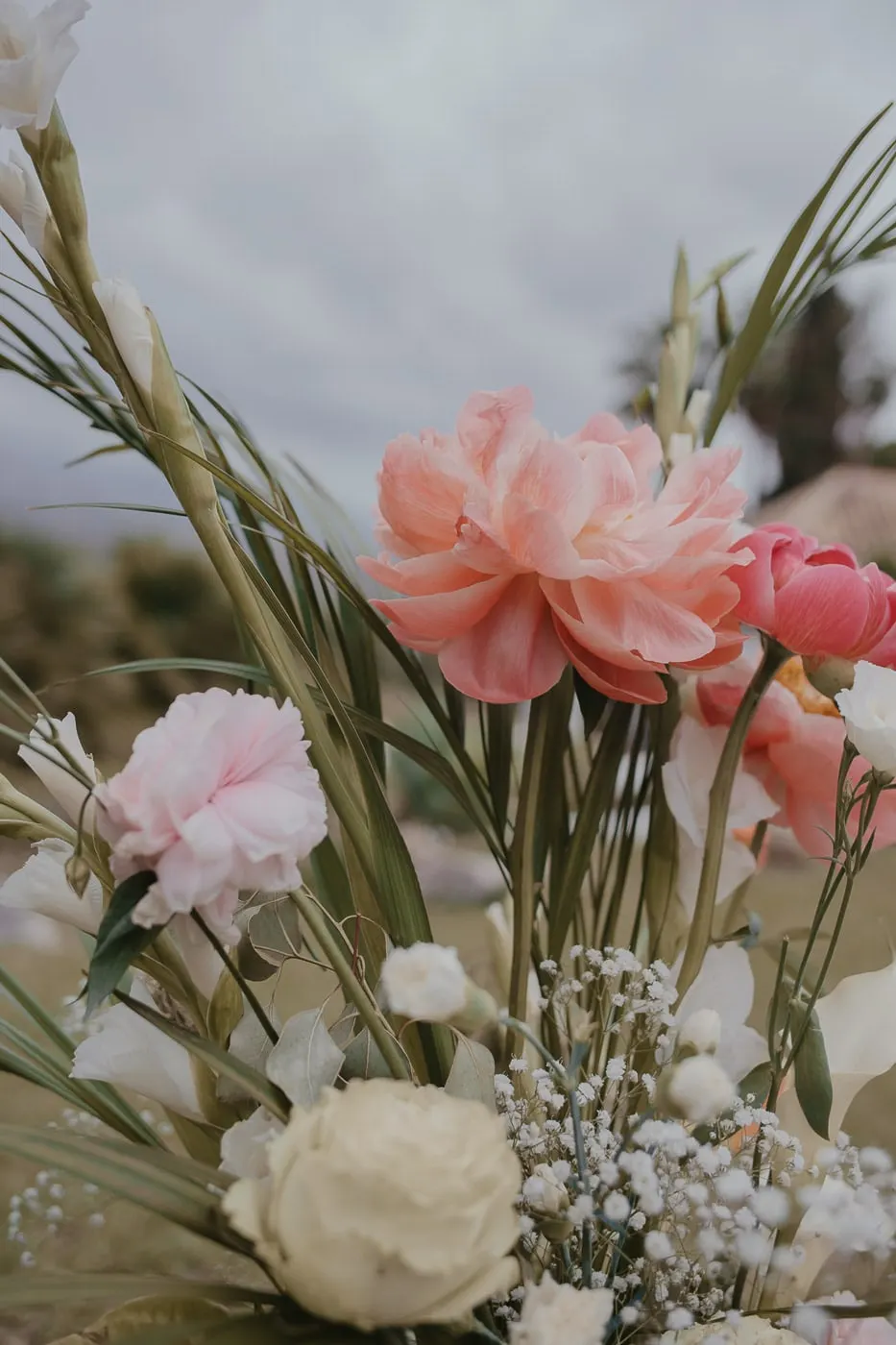 Close-up of a ceremony arrangement with coral peonies, pink carnations and baby's breath, Hacienda San José, Mijas