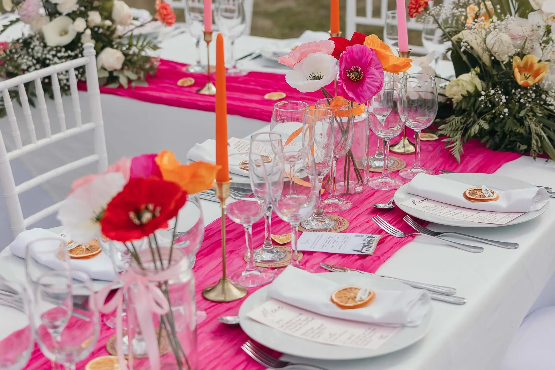 Reception table with a pink runner, orange candles, poppies and dried orange place cards, Hacienda San José, Mijas