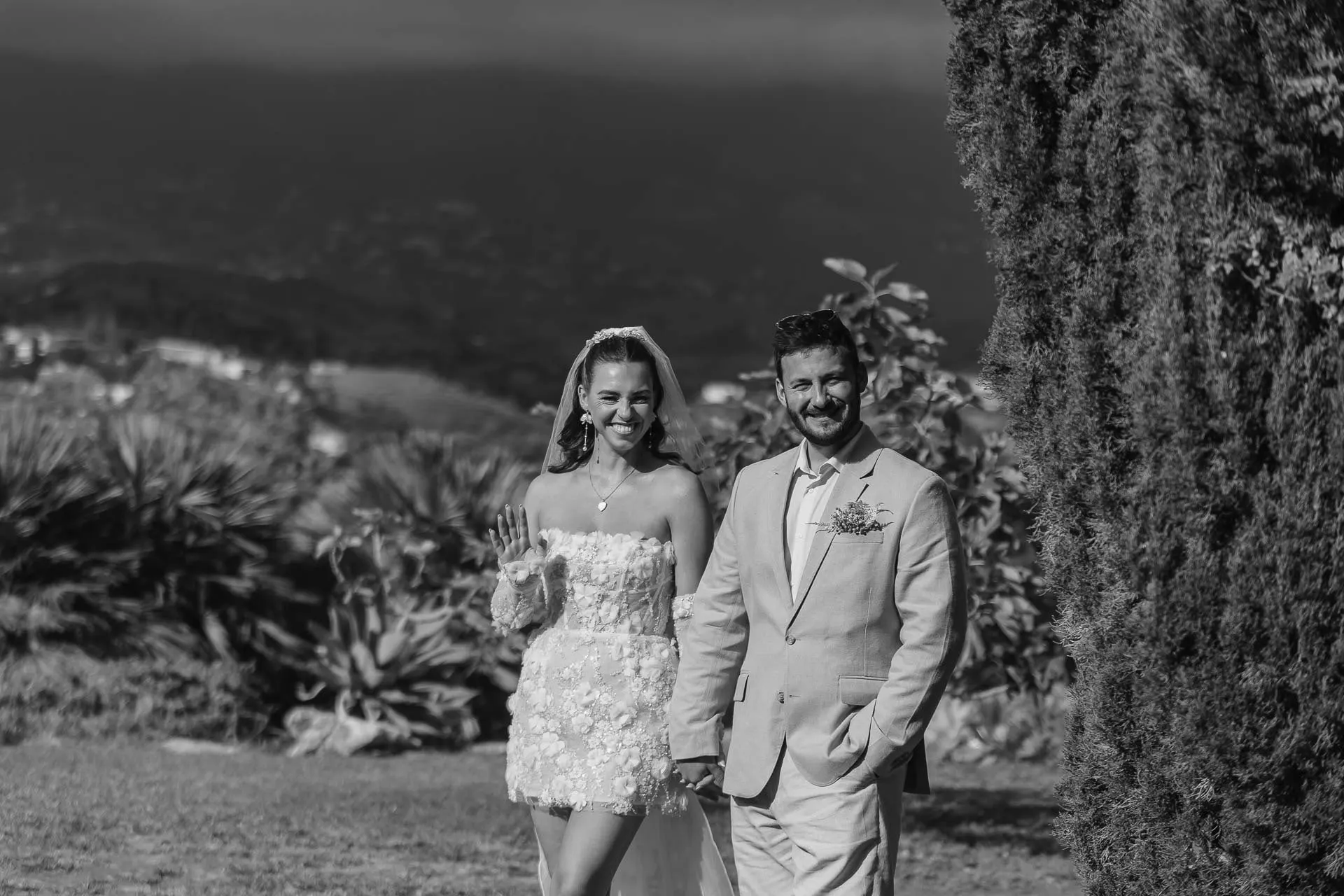 Black and white of the bride and groom strolling hand in hand through the garden, Hacienda San José, Mijas