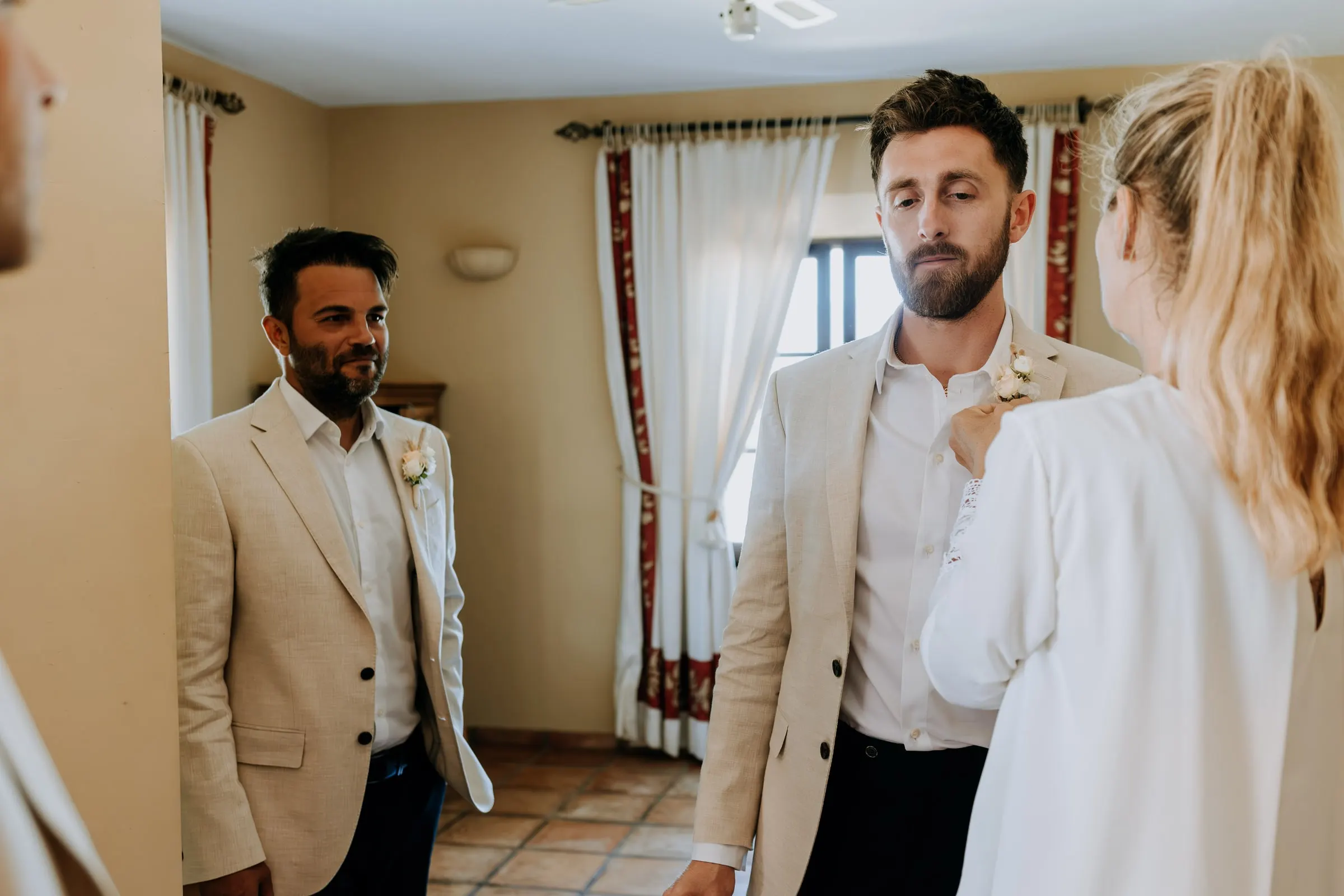 Groomsman having his buttonhole pinned in the groom's room, Mijas