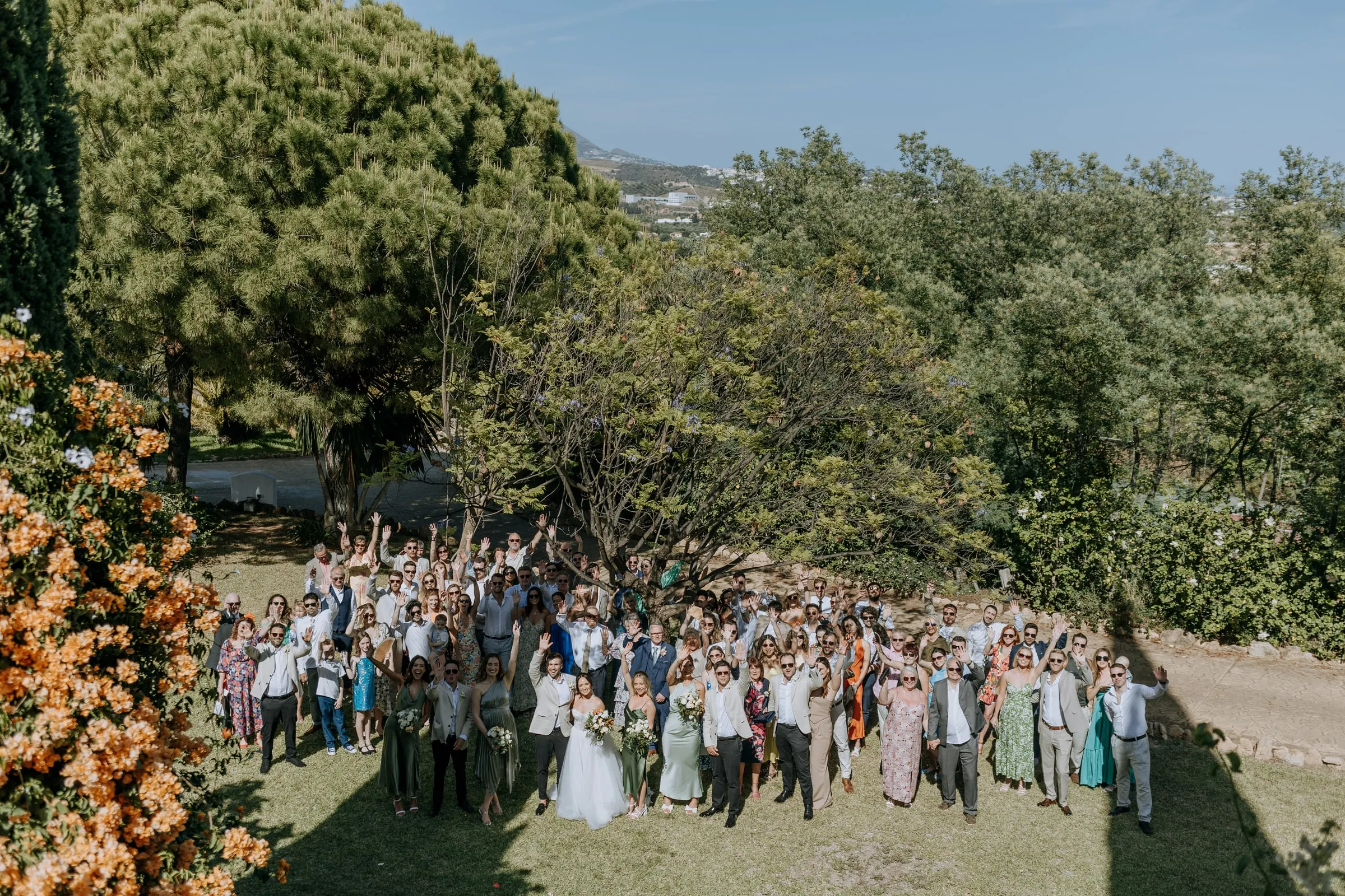 Group photo from above with all the guests waving on the lawn, Hacienda San José, Mijas