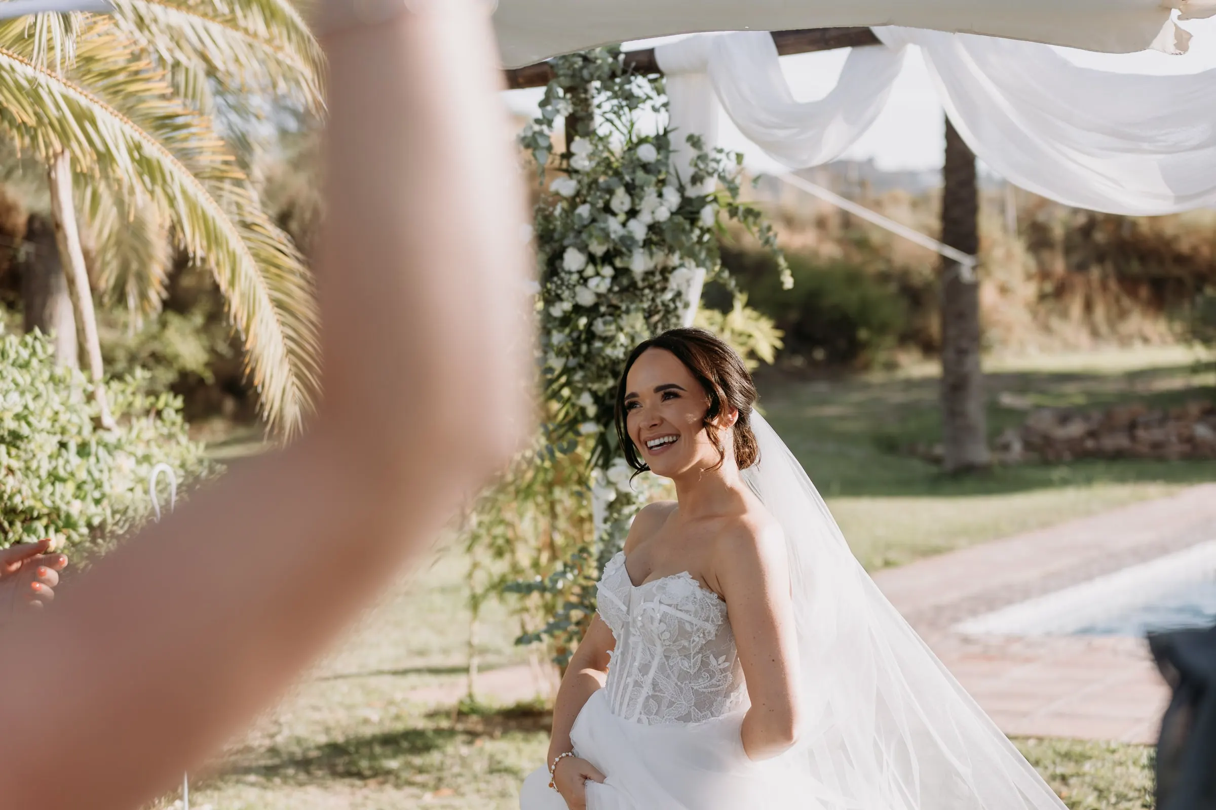 Bride laughing during the reception by the ceremony arch, Mijas