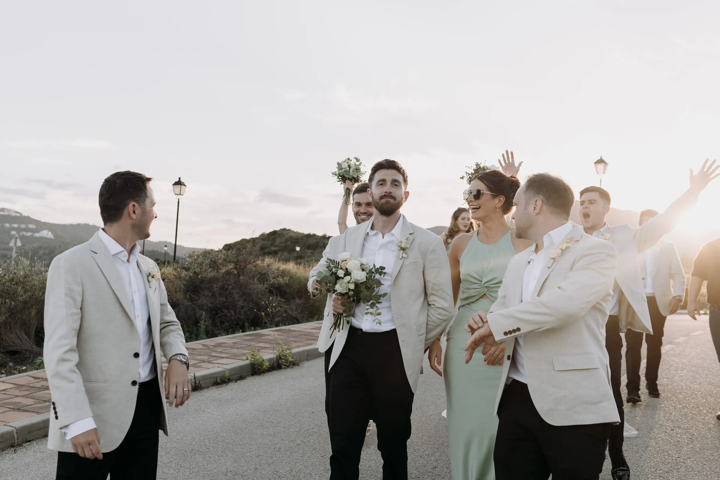 Bridal party cheering around the couple at sunset near Hacienda San José