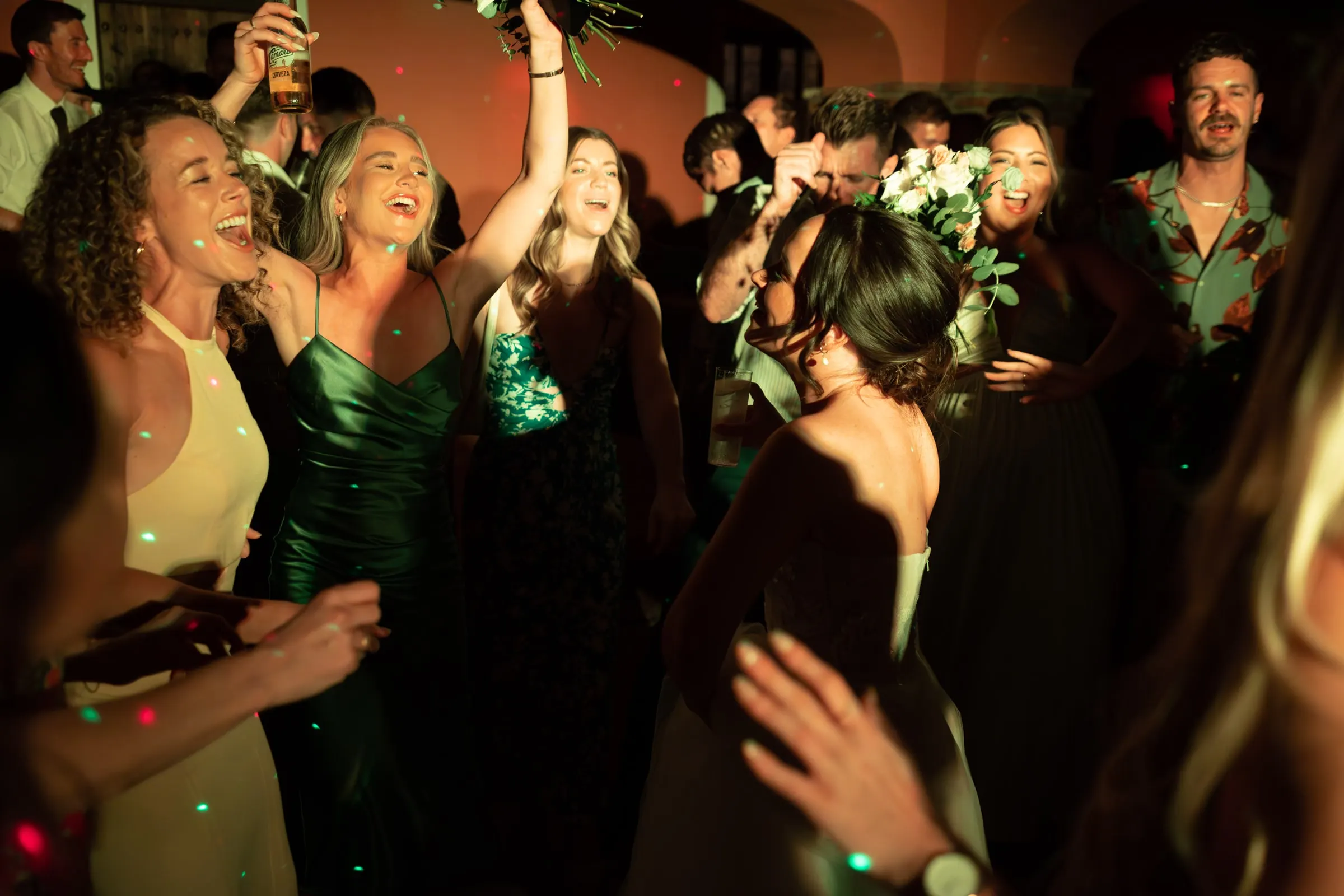 Friends singing and cheering around the bride on the dance floor, Hacienda San José