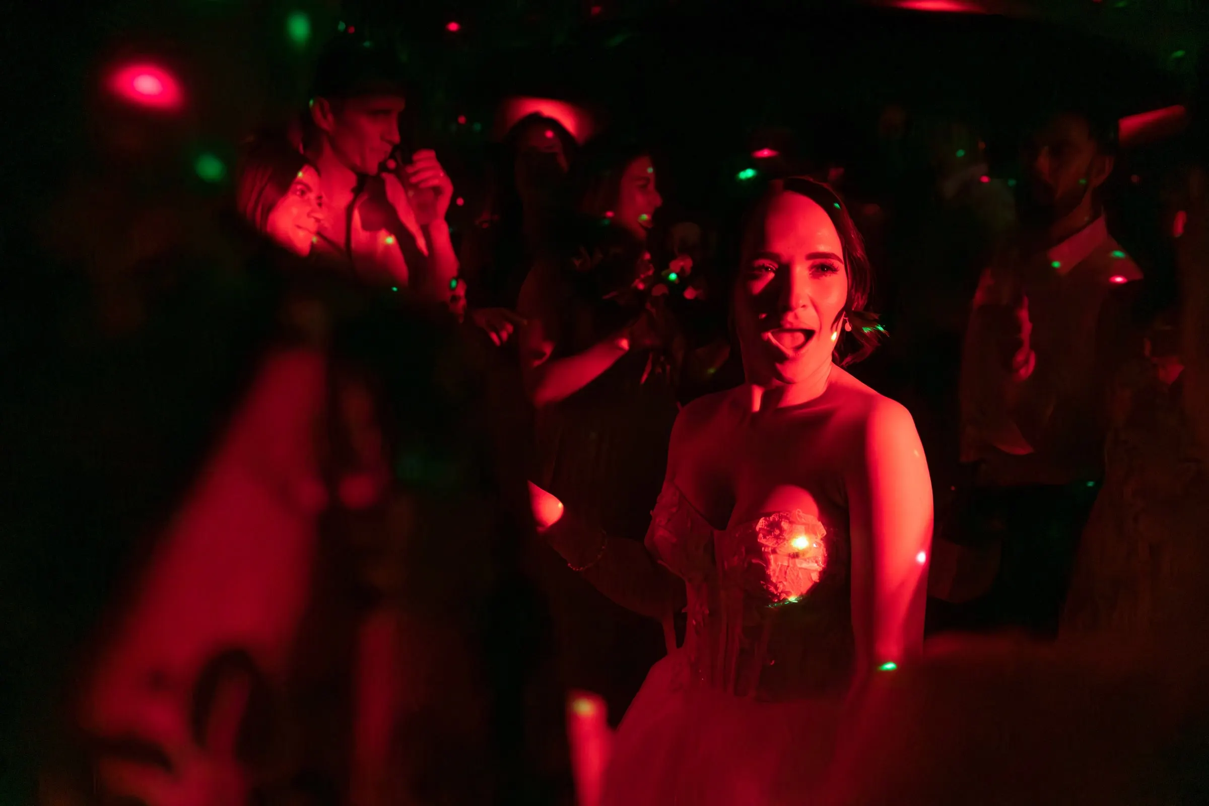 Bride dancing in red light at the wedding party, Mijas