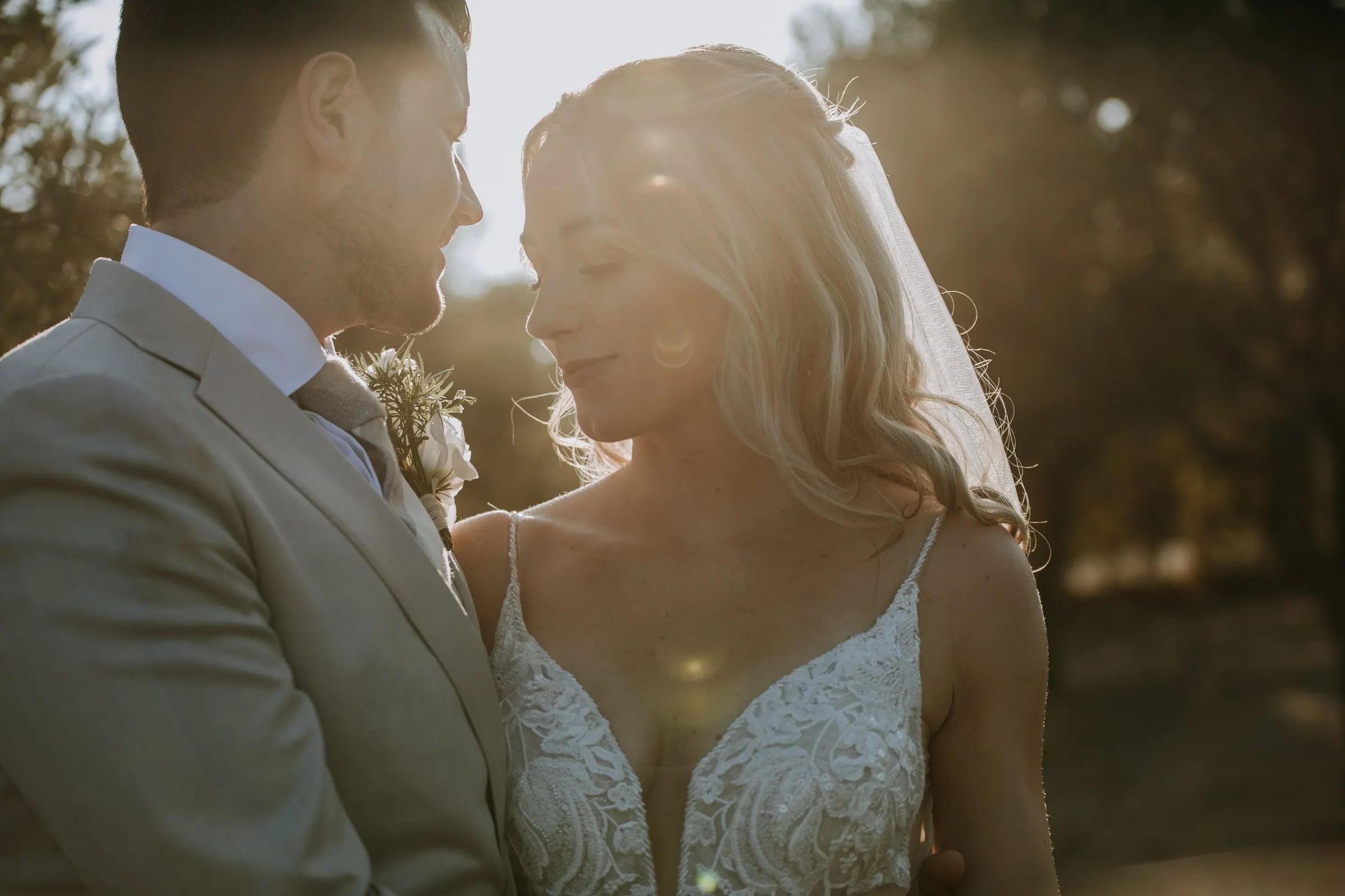 Backlit close-up of the bride and groom face to face, about to kiss, Hacienda San José, Mijas