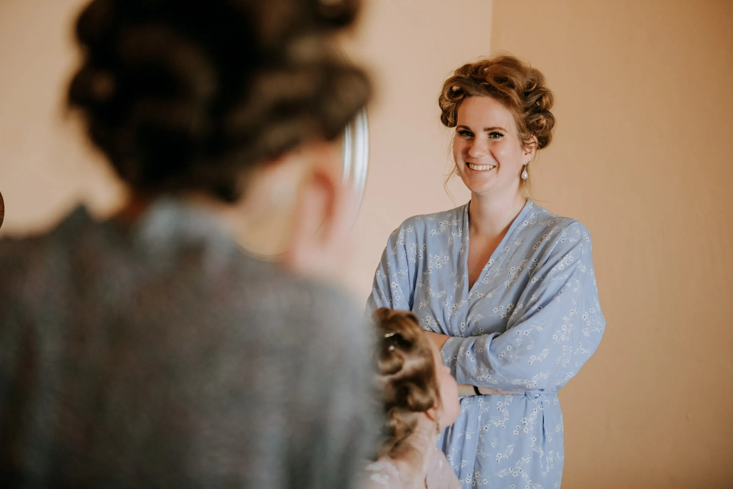 Woman in a blue floral robe and hair rollers laughing during the morning preparations, Hacienda San José, Mijas