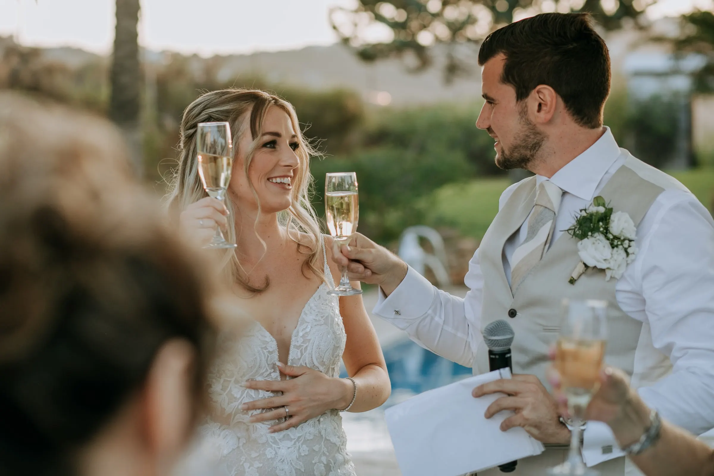 Bride and groom clink glasses of cava during the speeches by the pool, Hacienda San José, Mijas