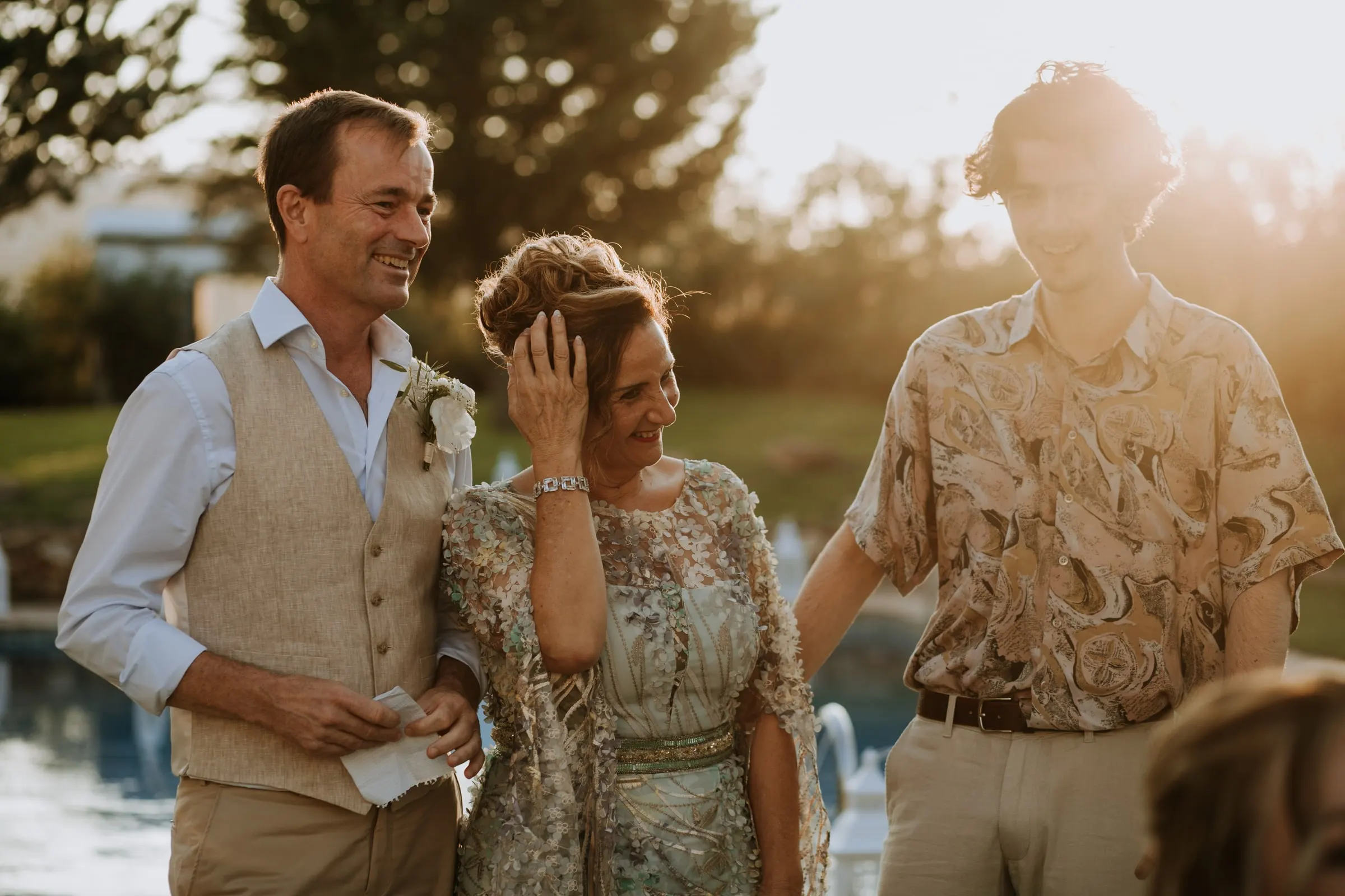 Family members smiling and wiping a tear in warm evening light by the pool, Hacienda San José, Mijas