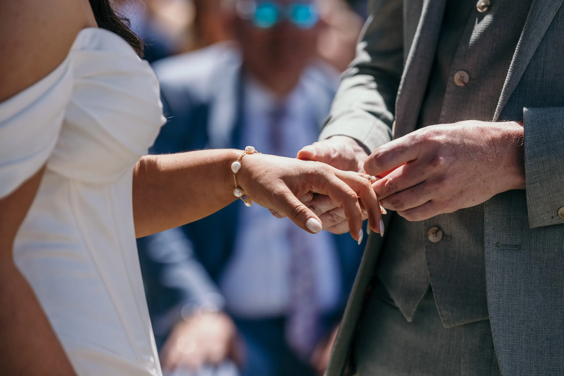 Close-up of the groom sliding the wedding ring onto the bride's finger