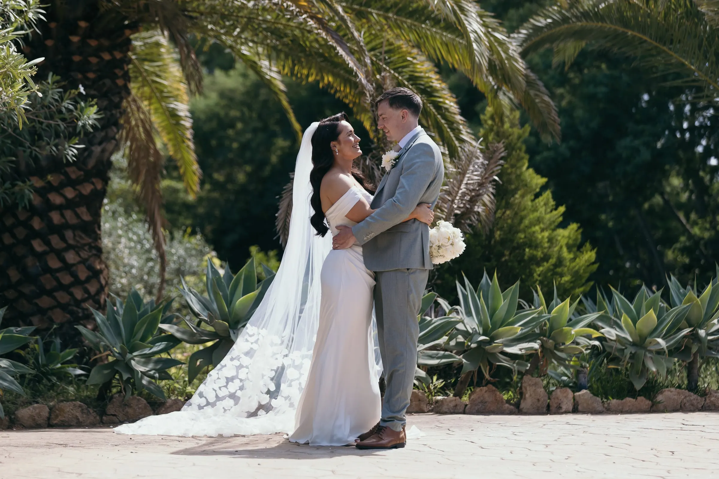 Newlyweds embracing among palms and agaves in the garden, Hacienda San José, Mijas
