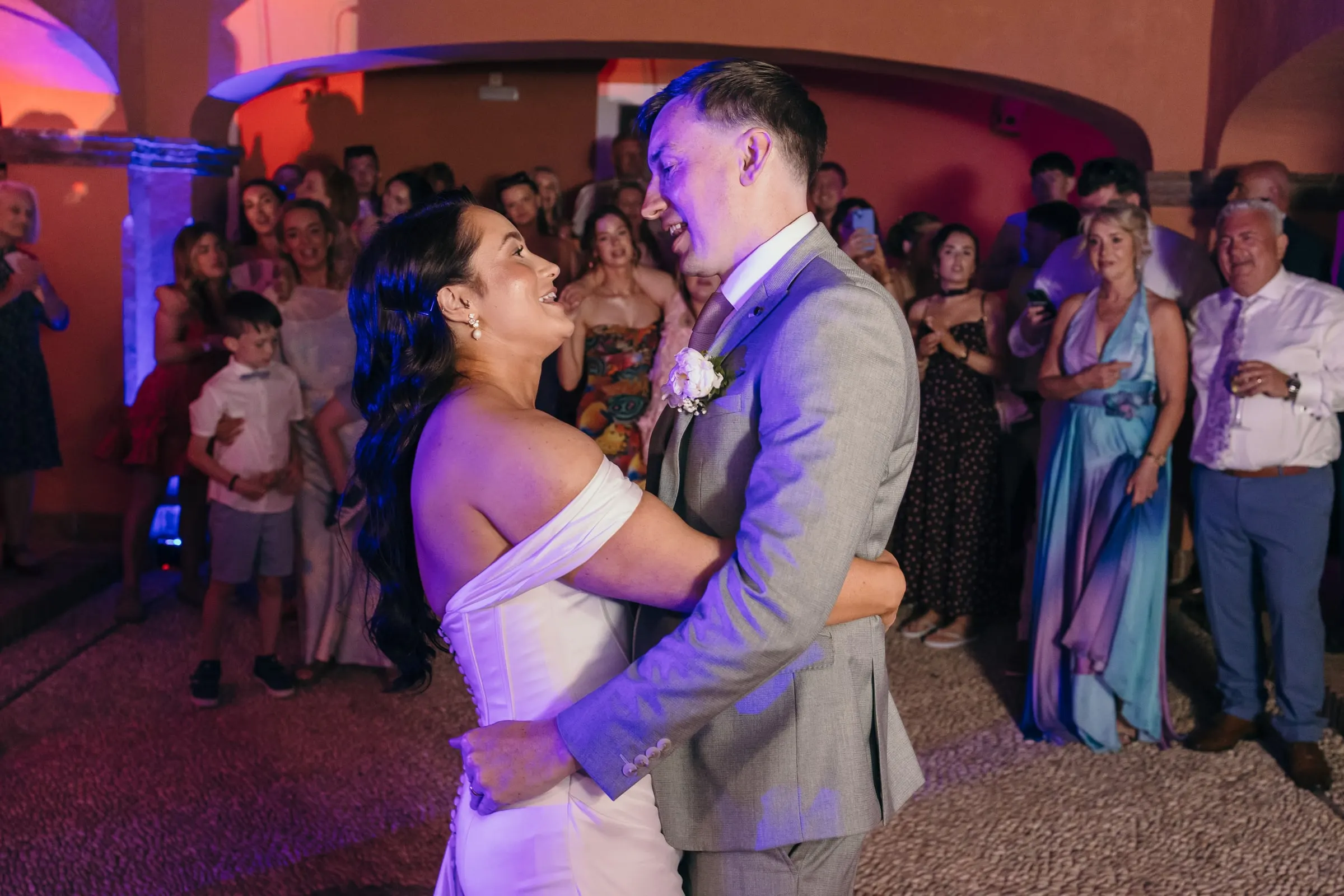 Bride and groom dancing in the courtyard surrounded by guests, Mijas